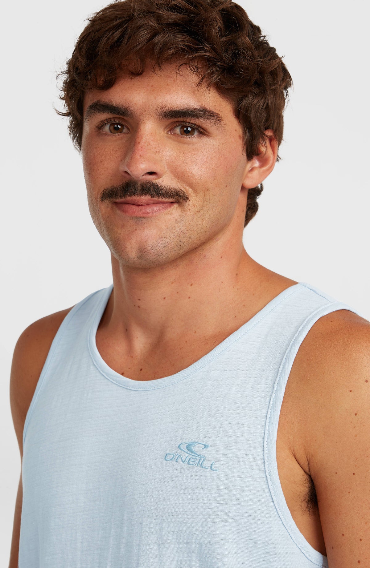 Nahaufnahme des blauen Slub Tanktop für Herren am Model mit dezentem Logo-Print am Ausschnitt