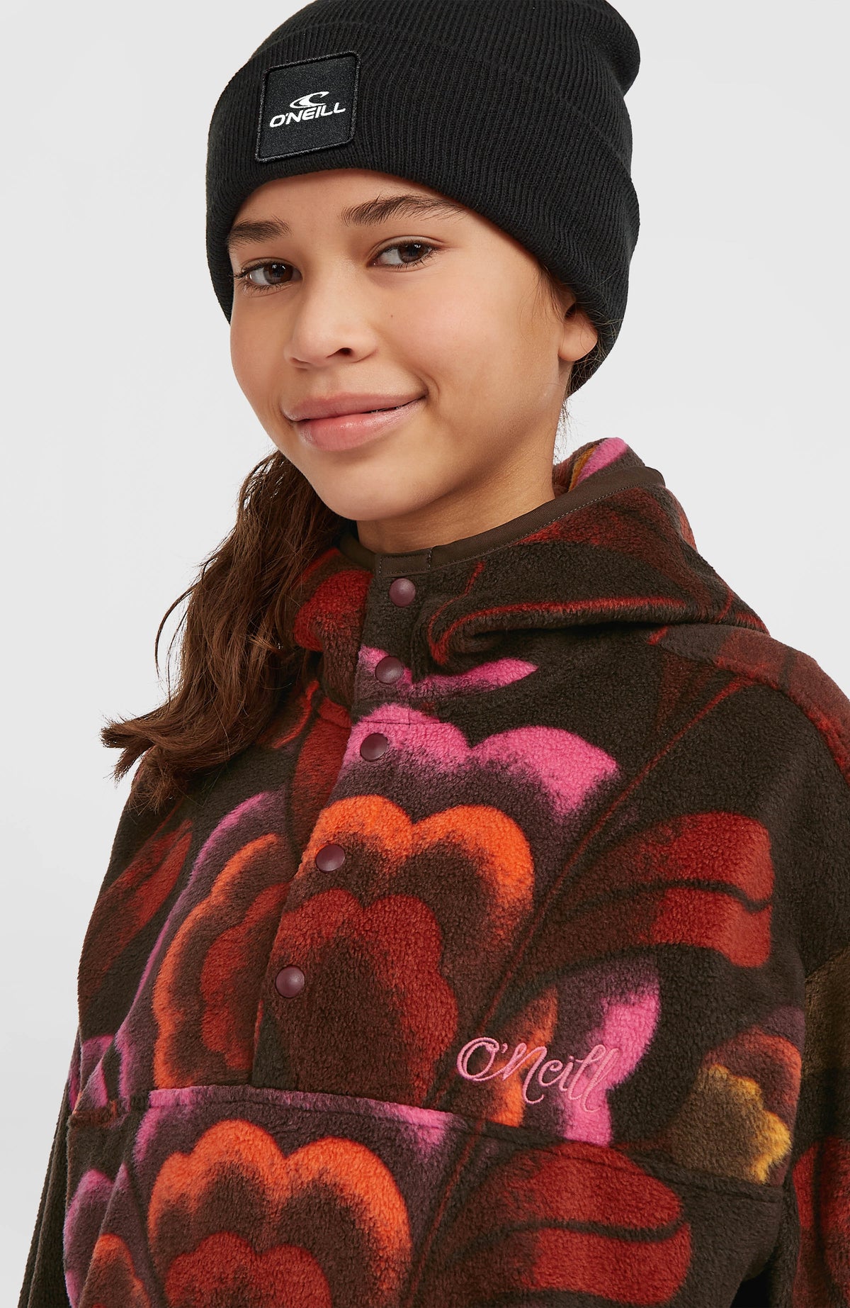Superfleece Hoodie für Mädchen, braun mit Blumenmuster in Pink und Orange, Nahaufnahme der Druckknopfleiste am Model