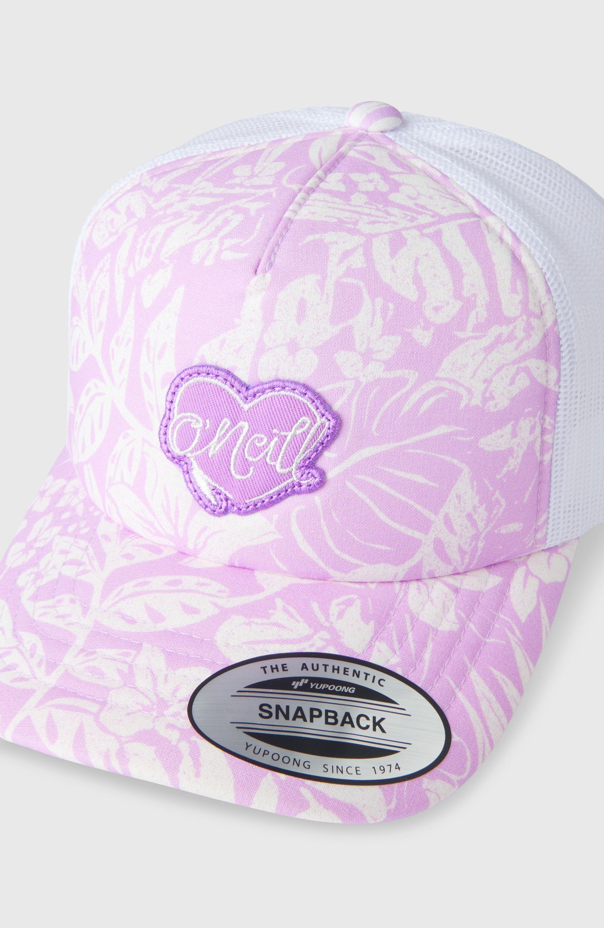 Summer Camp Trucker Cap, lila mit Pflanzenmuster in Weiß, Nahaufnahme von Schirm und herzförmigem Logo-Patch