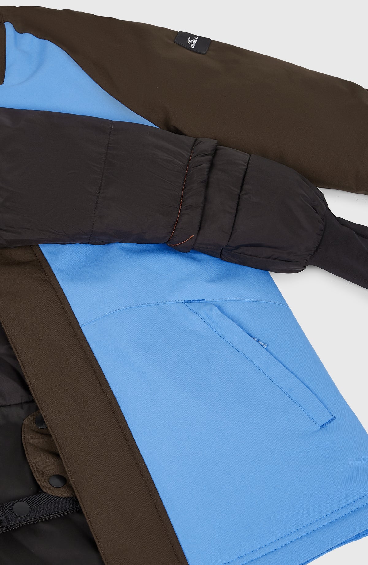 Nahaufnahme der blauen FWC'Play Ski- und Snowboardjacke für Mädchen mit sichtbarer Seitentasche und Innenfutter