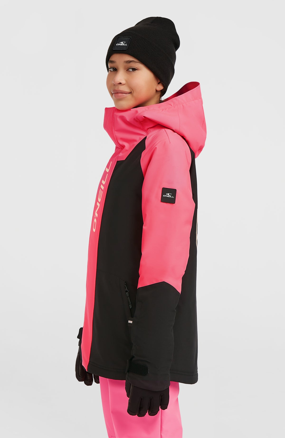 FWC'Play Ski- und Snowboardjacke für Mädchen, schwarz, Seitenansicht am Model mit Logo-Badge am Ärmel
