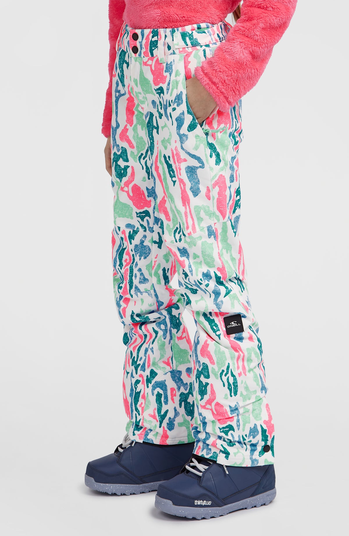 FWC'Cruz Skihose für Mädchen, weiß mit Allover-Muster in Pink und Türkis, Seitenansicht mit Logo-Badge am Model