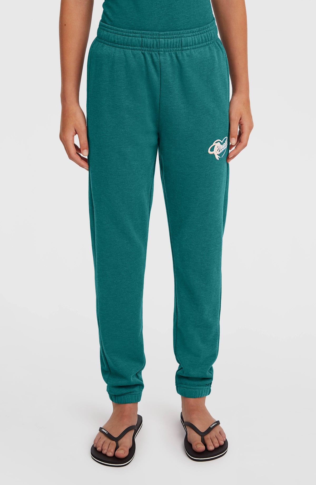 Essentials Script Jogginghose für Mädchen, grün, Vorderansicht am Model mit elastischem Bund und Bündchen