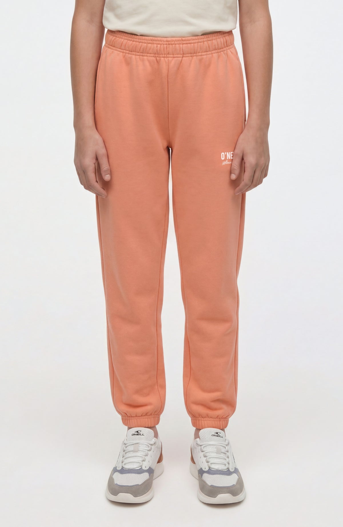 O'Neill Essentials Jogginghose für Mädchen, orange mit Logo-Print in Weiß, Vorderansicht am Model