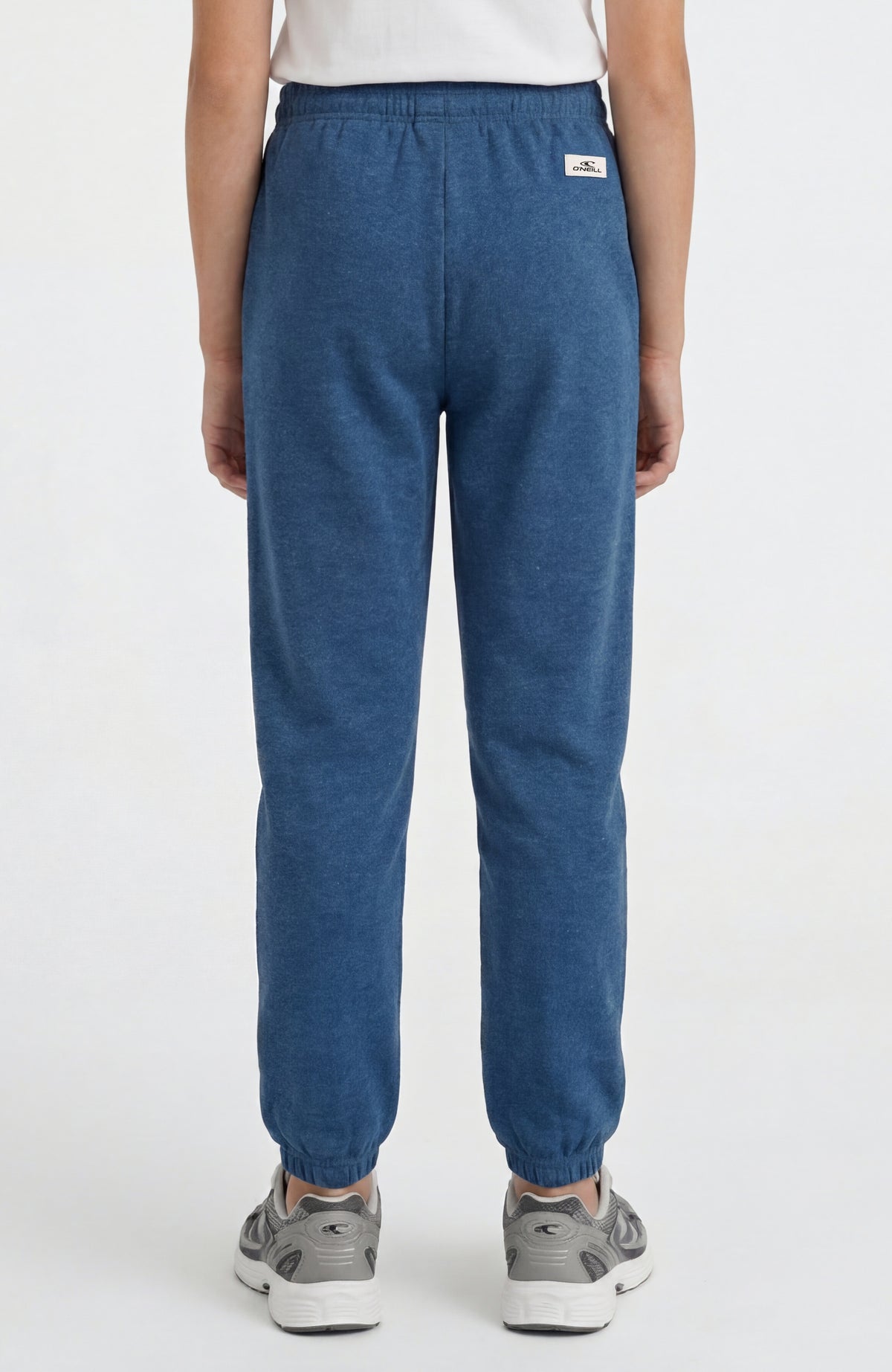 Essentials Jogginghose für Mädchen, blau, Rückansicht getragen am Model mit kleinem Logo-Patch am Bund
