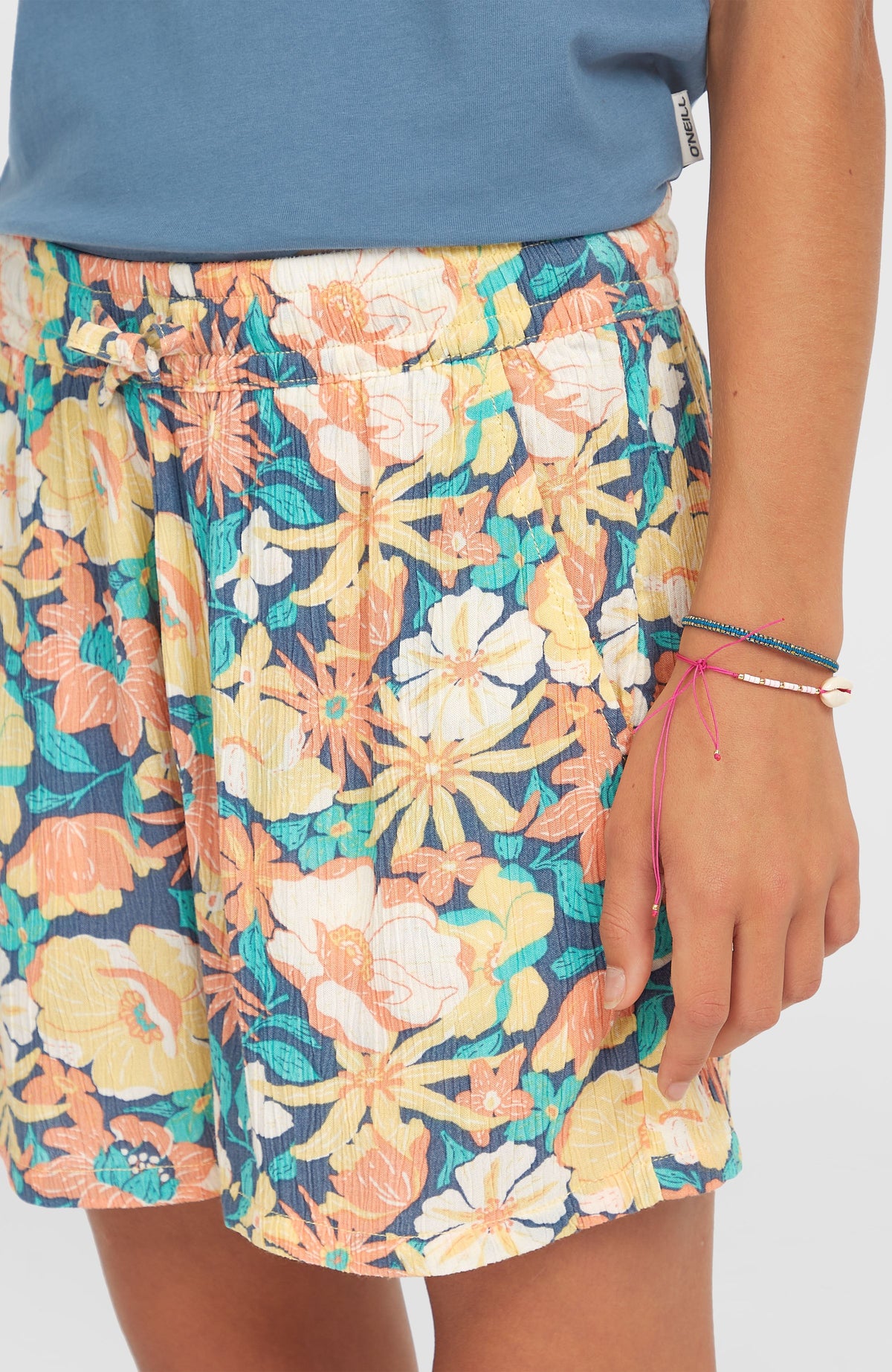 Gewebte Sommershorts für Mädchen, blau mit Blumenmuster in Gelb und Orange, Nahaufnahme des elastischen Bundes