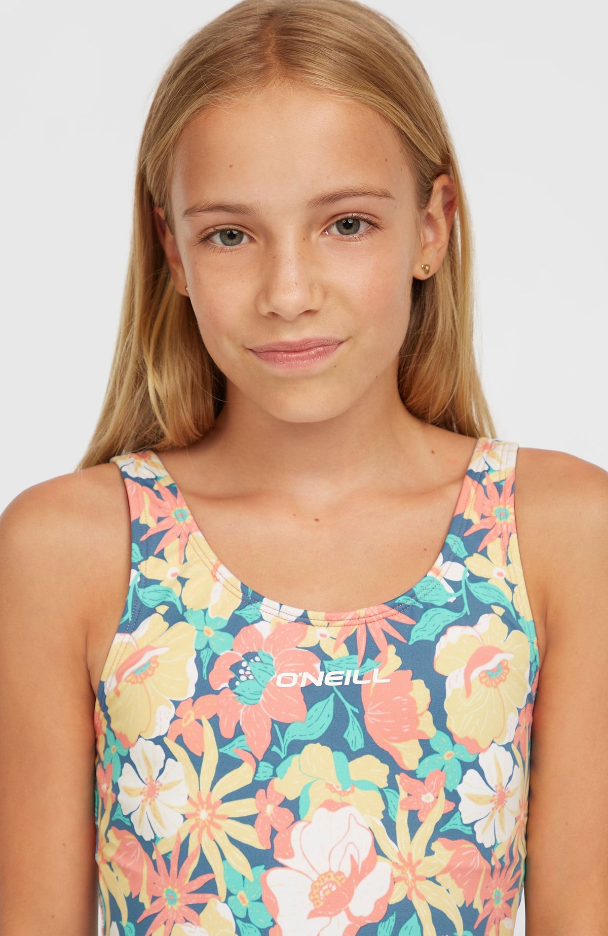 Cali Holiday Badeanzug für Mädchen, blau mit Blumenmuster in Gelb und Rosa, Nahaufnahme des Oberteils am Model