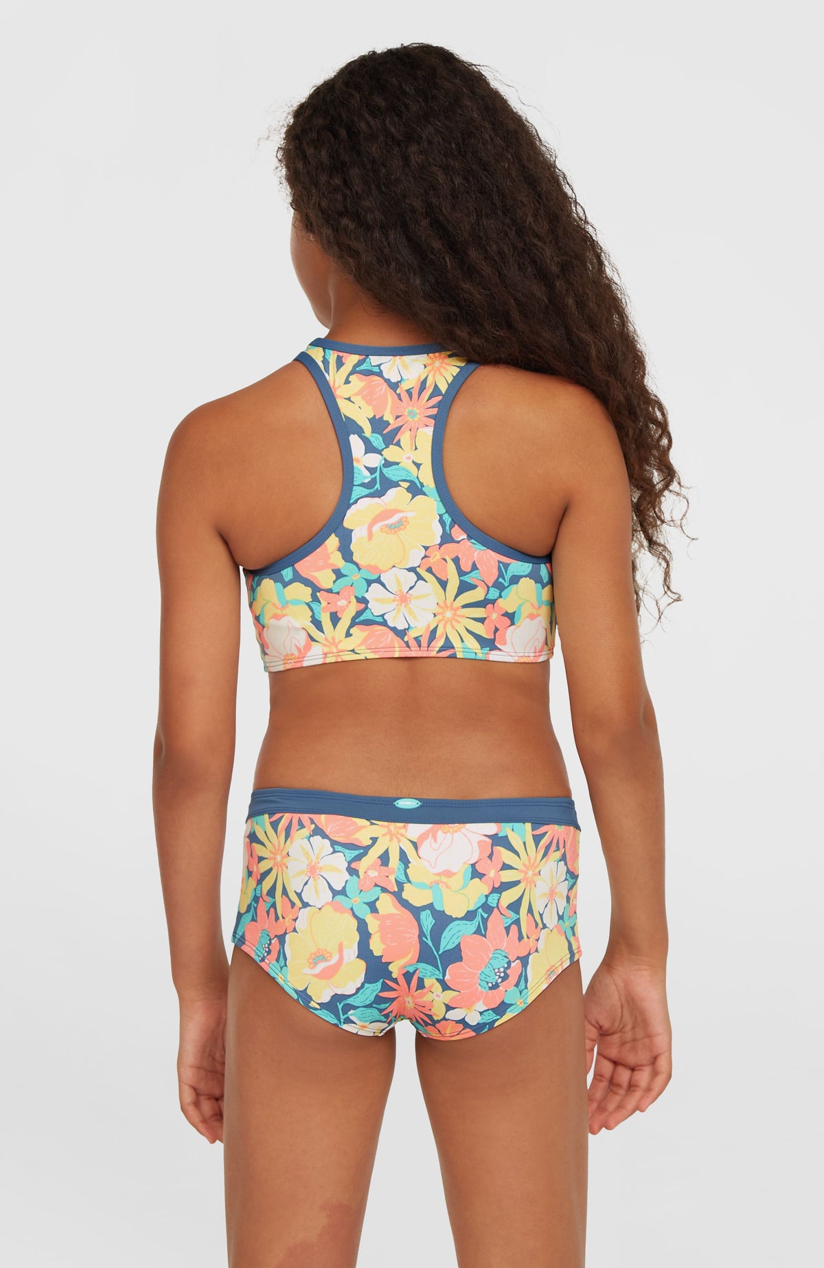 Cali Holiday Bikini-Set für Mädchen, blau mit Blumenmuster in Gelb und Rosa, Rückansicht am Model mit Racerback