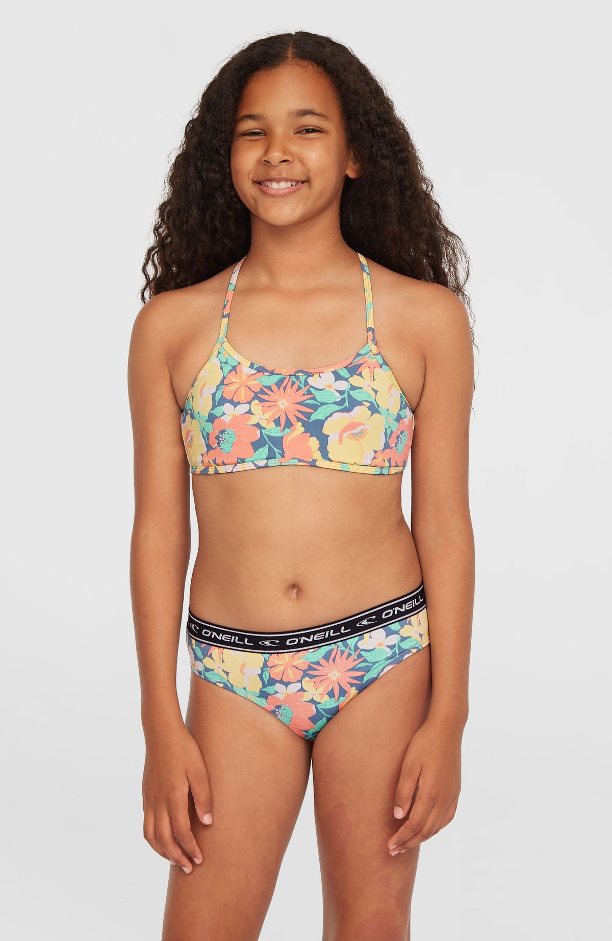 O'Neill Sportclub Bikini-Set für Mädchen, blau mit Blumenmuster in Gelb und Rosa, Vorderansicht am Model