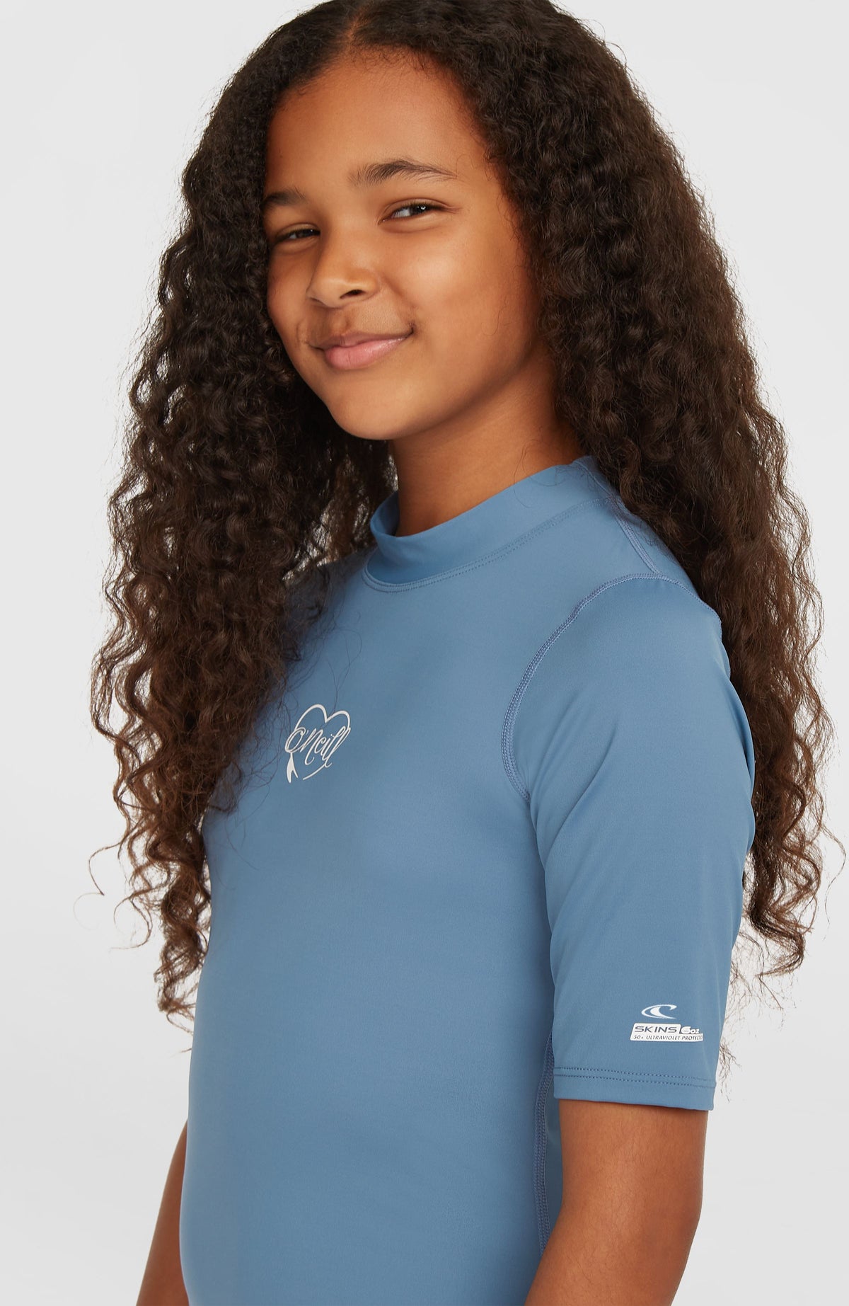 Essentials Shortsleeve-Schwimmshirt für Mädchen, blau, Nahaufnahme am Model mit Stehkragen und Logo-Print