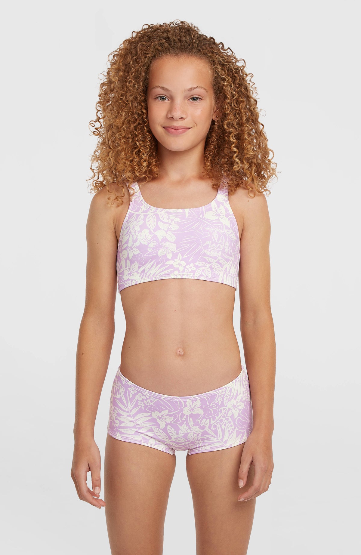 O'Neill Holiday Bikini-Set für Mädchen, lila mit Blumenmuster in Weiß, Vorderansicht am Model
