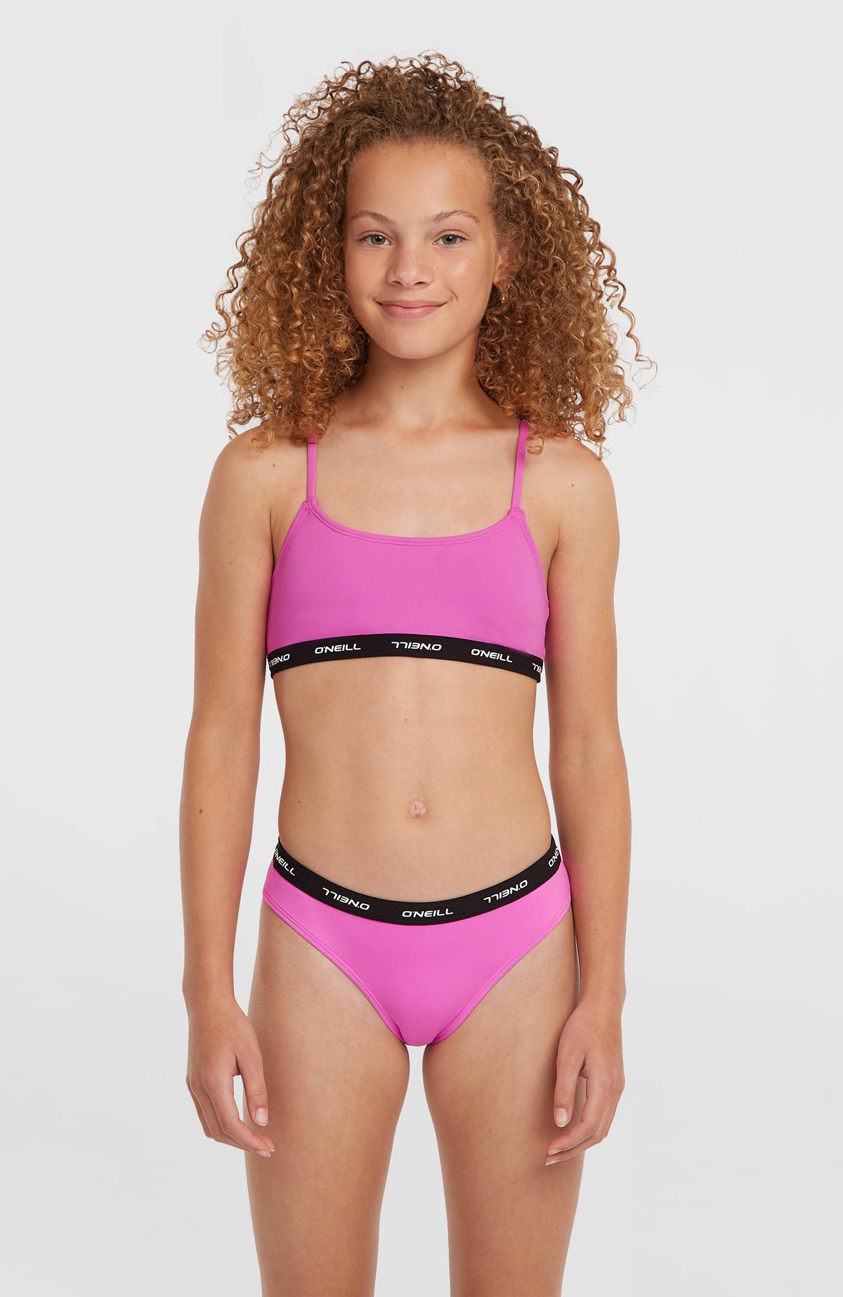 O'Neill Sport Bikini-Set für Mädchen, lila, Vorderansicht am Model mit Logo-Schriftzug am elastischen Bund