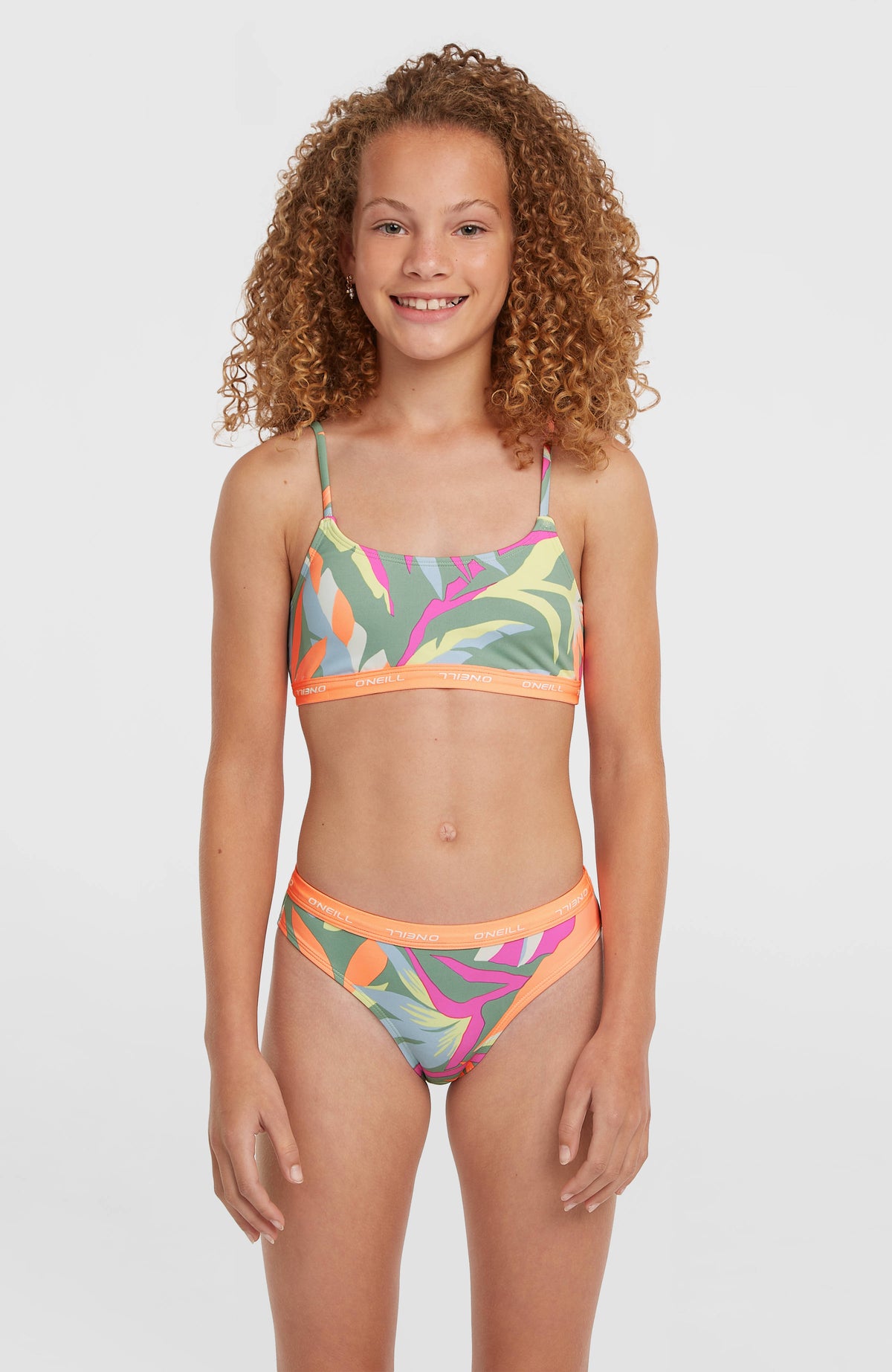 O'Neill Sport Bikini-Set für Mädchen, grün mit Tropenmuster in Pink und Orange, Vorderansicht getragen am Model