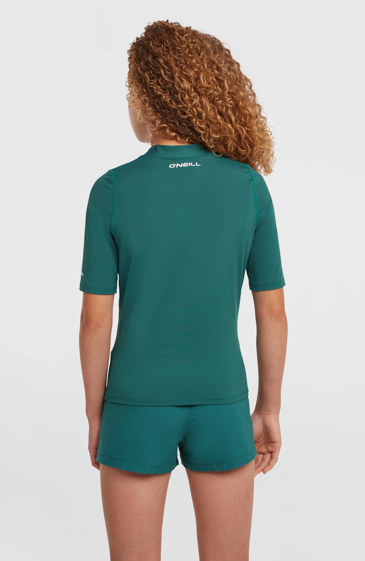 Shortsleeve-UV-Shirt für Mädchen, grün, Rückansicht am Model mit weißem Logo-Schriftzug unter dem Kragen