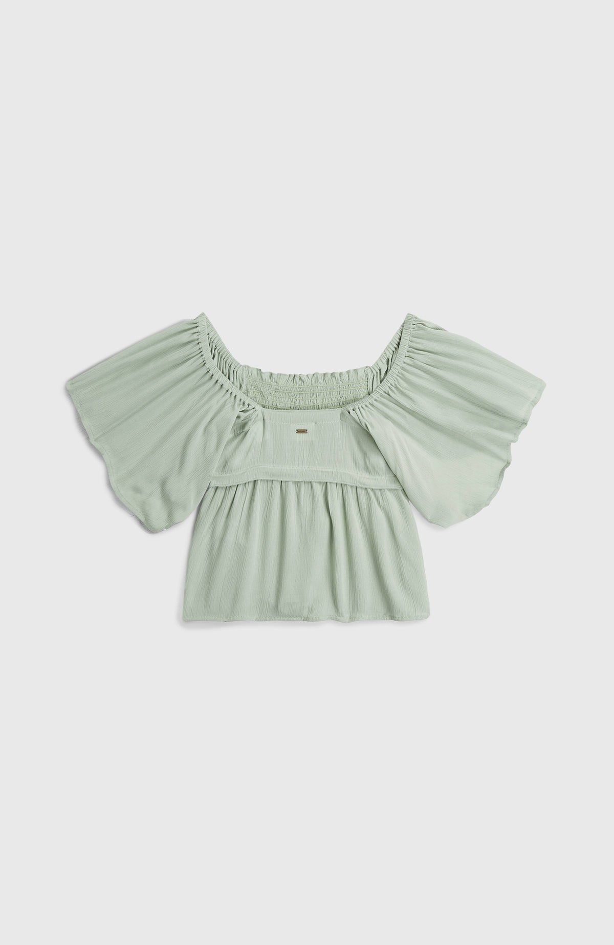 Grünes Woven T-Shirt für Mädchen, flach liegend von hinten mit kleinem Logo-Badge