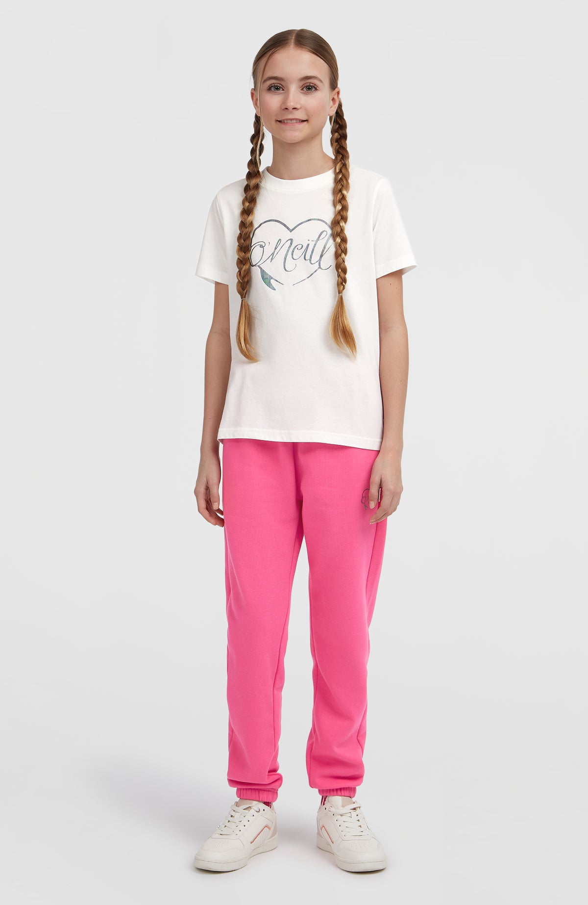 Essentials T-Shirt für Mädchen, weiß mit Logo-Print in Silber, getragen am Model in der Ganzkörperansicht