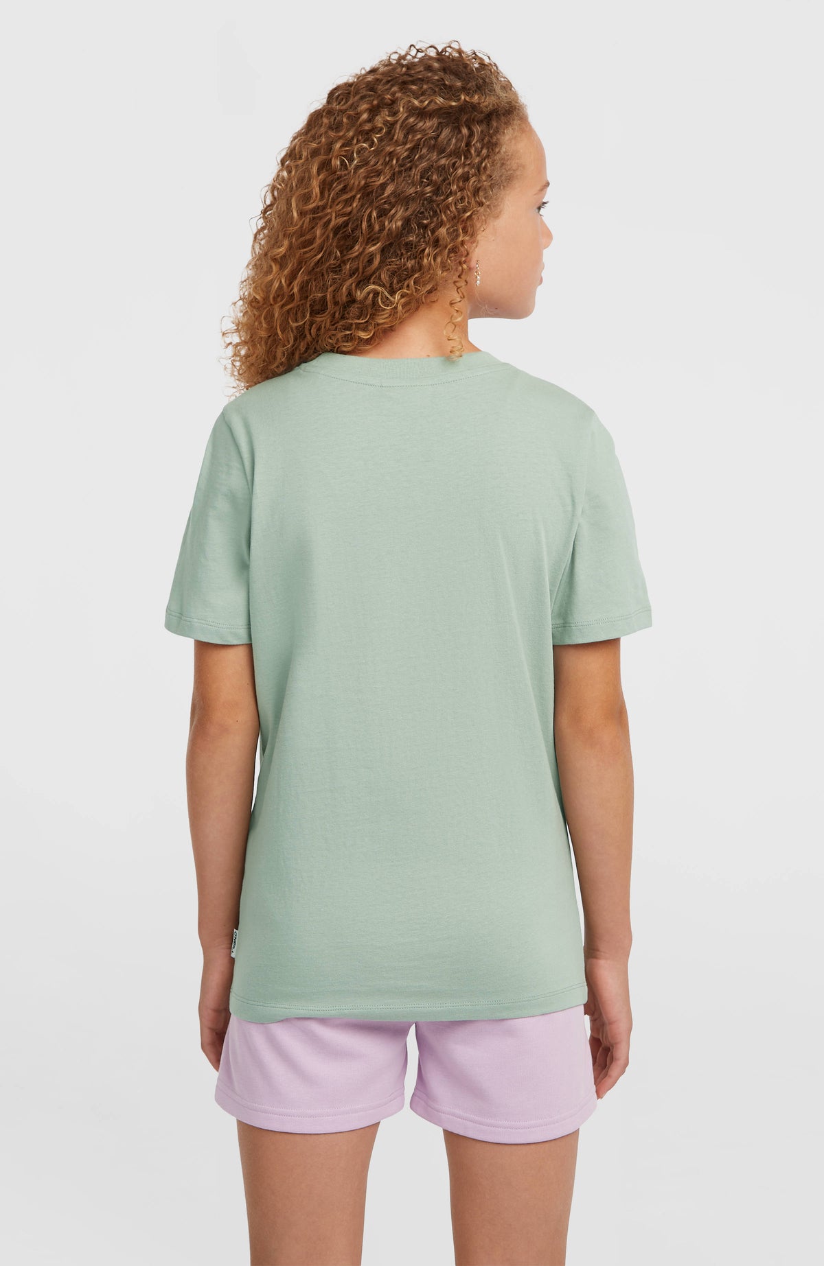 Graphic T-Shirt für Mädchen, grün, Rückansicht am Model mit dezentem Logo-Label am Saum