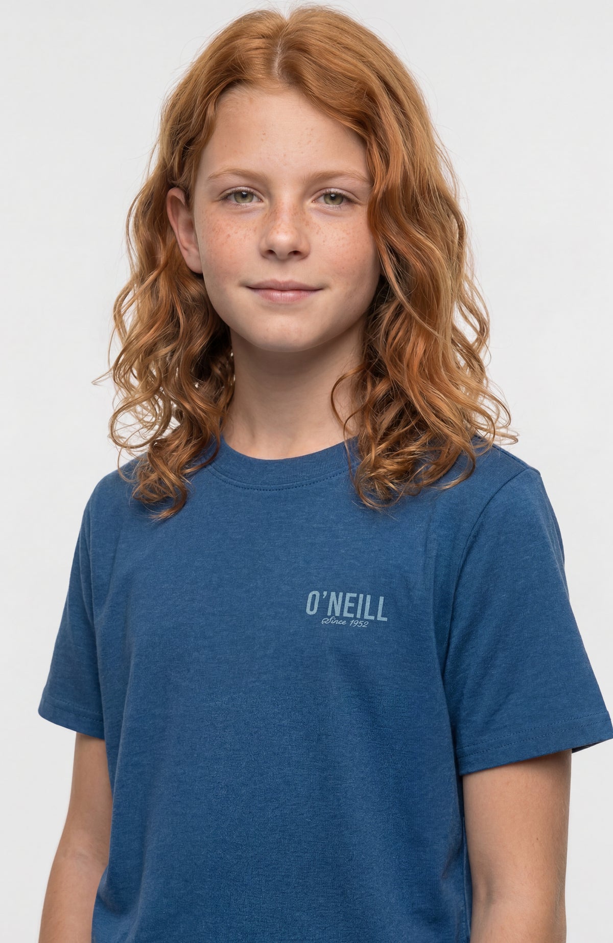 Blaues Essentials T-Shirt für Mädchen, Nahaufnahme am Model mit Rundhalsausschnitt und Logo-Print