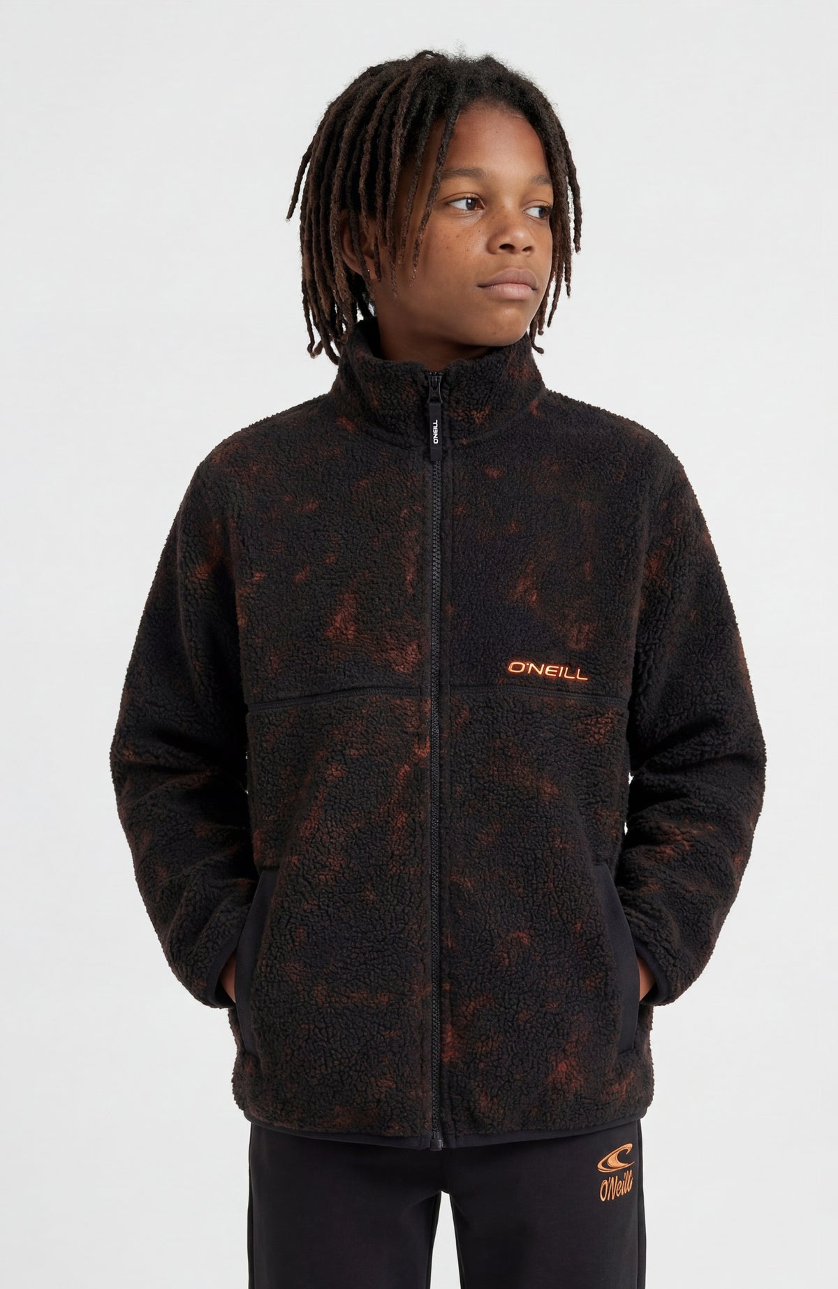 O'Neill Flauschige Fleecejacke mit Reißverschluss für Jungen, schwarz mit Batikmuster in Orange, getragen am Model