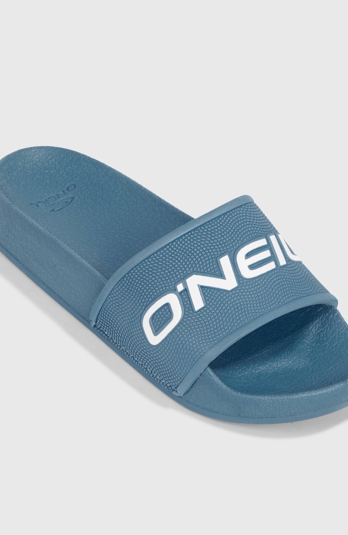 Logo Slides für Jungen, blau mit Logo-Print in Weiß, Nahaufnahme des Riemens von schräg oben