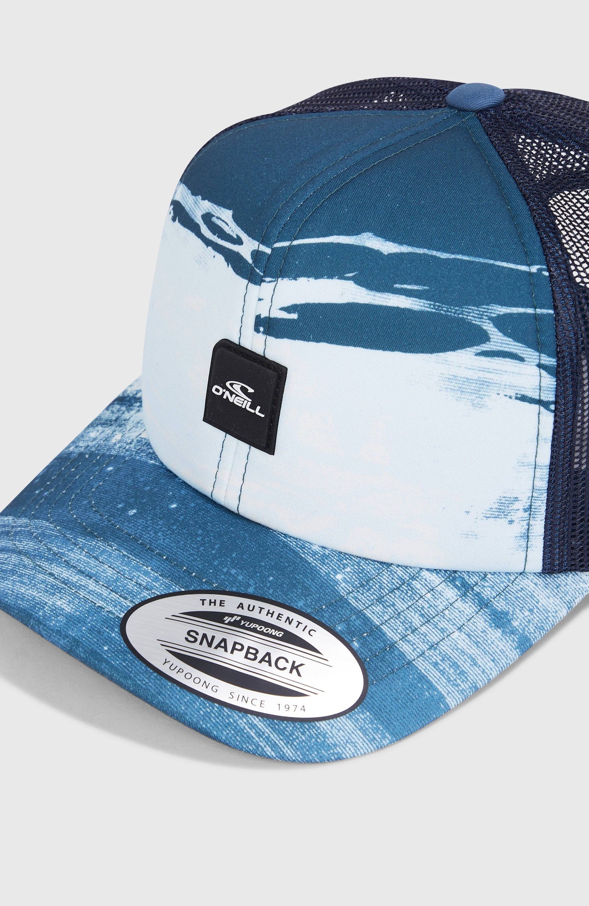 Nahaufnahme der blauen Flood Trucker Cap für Jungen mit Streifenmuster in Weiß und Logo-Patch