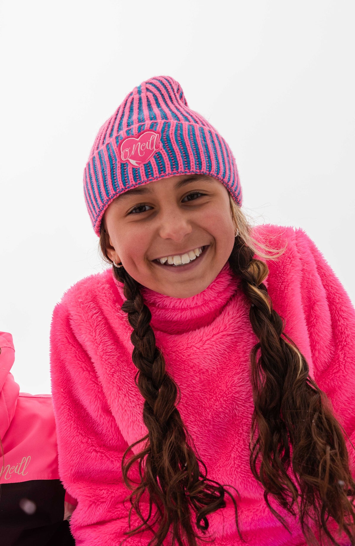 Beanie für Jungen, blau mit Streifenmuster in Pink, getragen am Model im Schnee, Ansicht von vorne