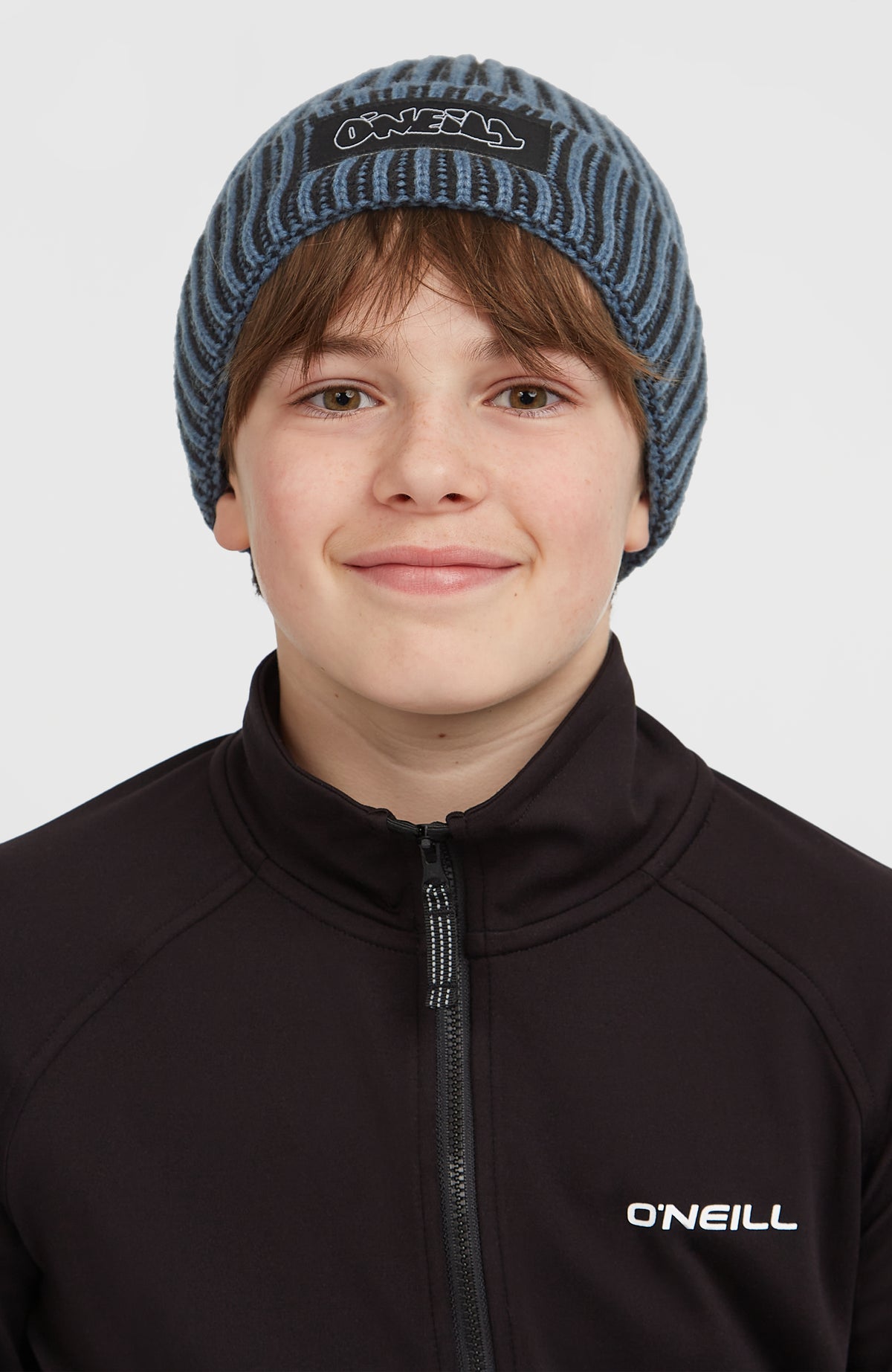 Beanie für Jungen, schwarz mit Streifenmuster in Blau, getragen am Model, Frontalansicht mit Umschlag