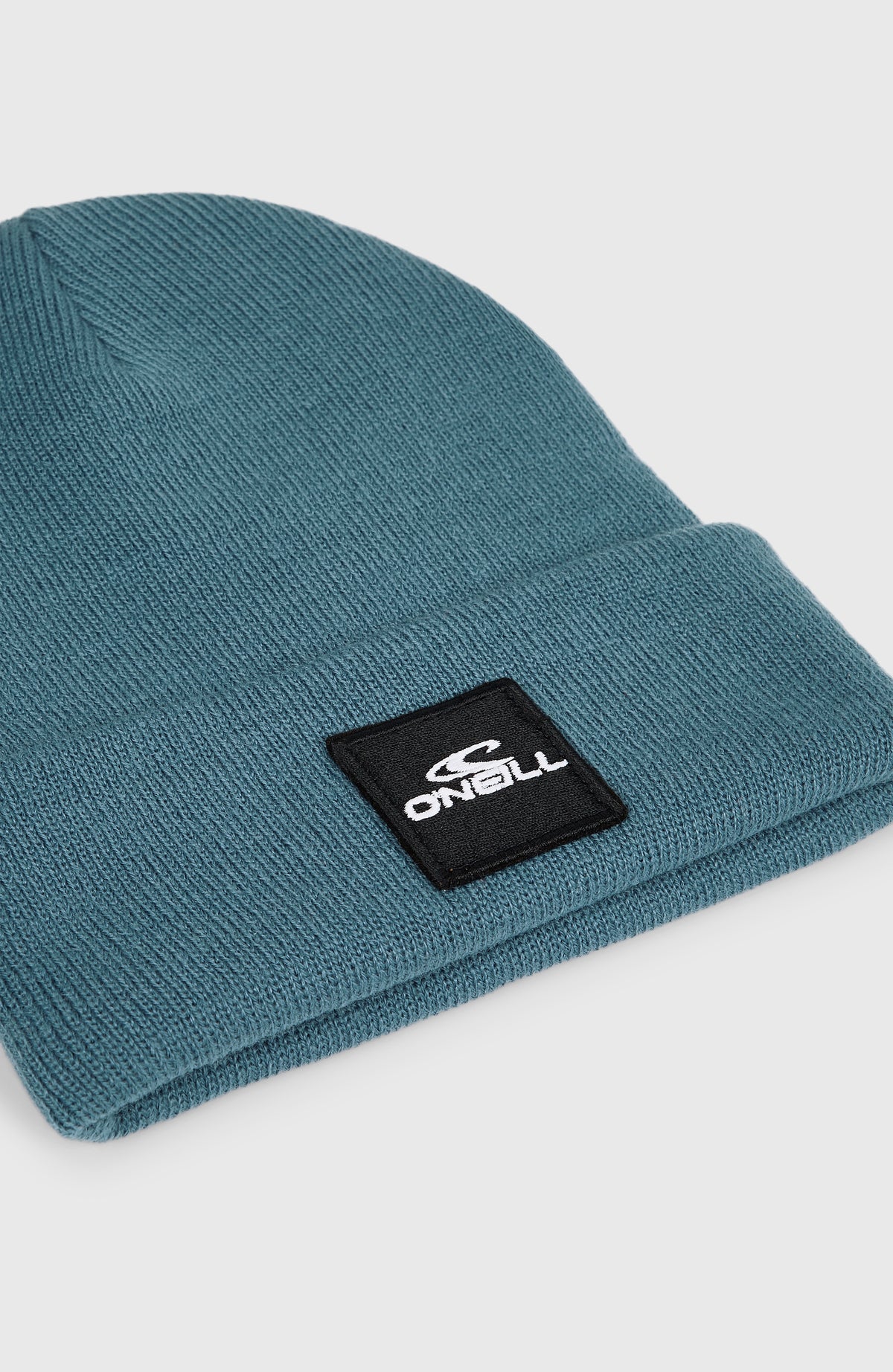 Nahaufnahme des Umschlags mit aufgenähtem Logo-Patch der blauen Snow Beanie