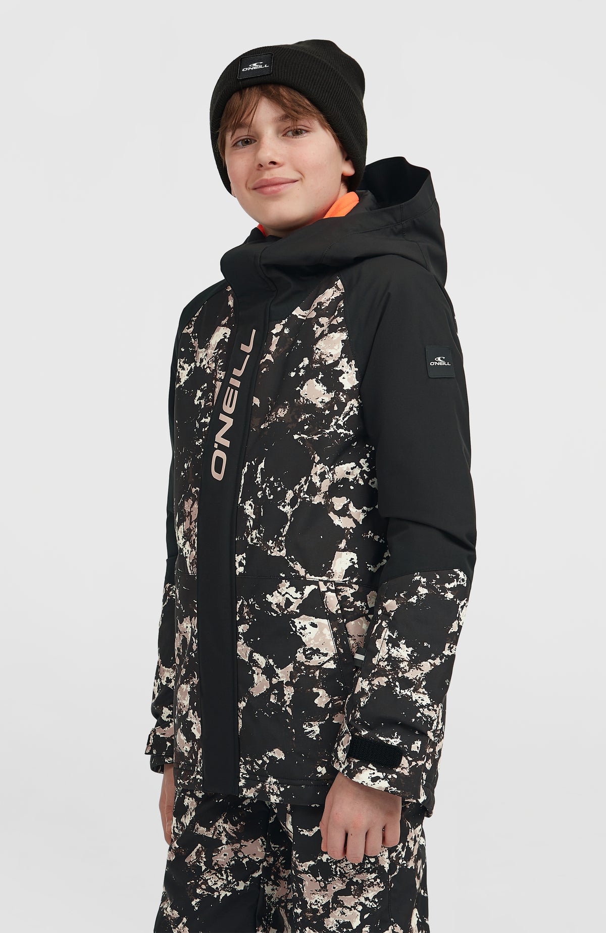 FWC'Play Ski- und Snowboardjacke für Jungen, schwarz mit Marmormuster in Beige, Halbprofilansicht am Model