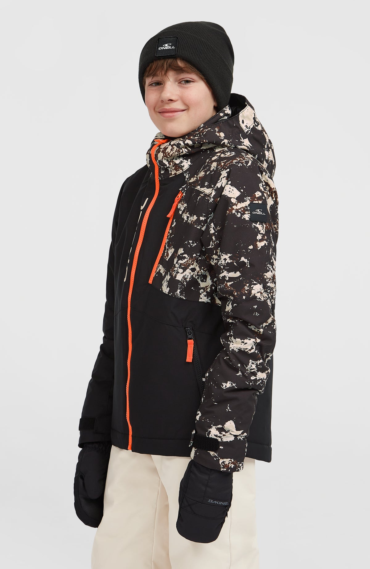 FWC'Cruz Block Skijacke für Jungen, schwarz mit Muster in Beige, Halbprofil am Model mit Logo-Patch am Ärmel