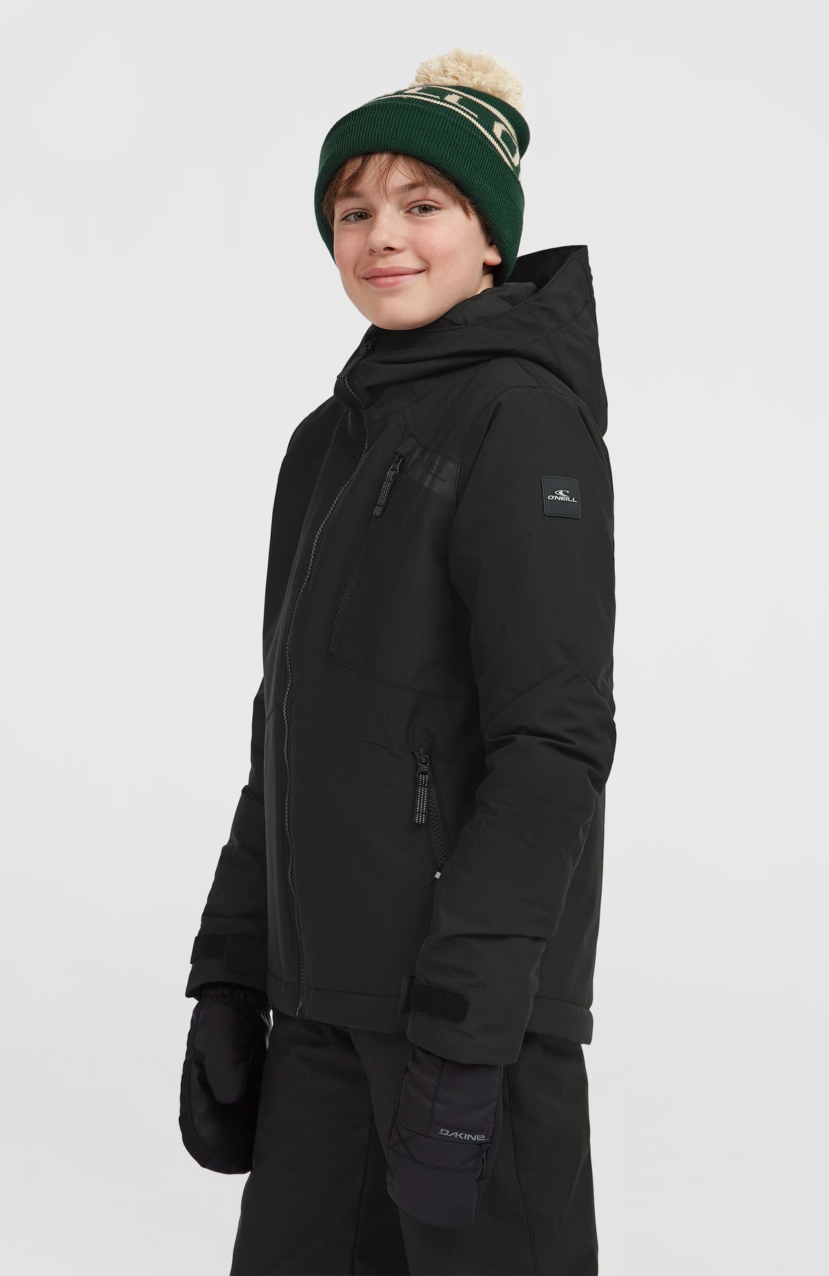 Schwarze FWC'Cruz Skijacke für Jungen, Seitenansicht am Model mit Logo-Patch am Ärmel