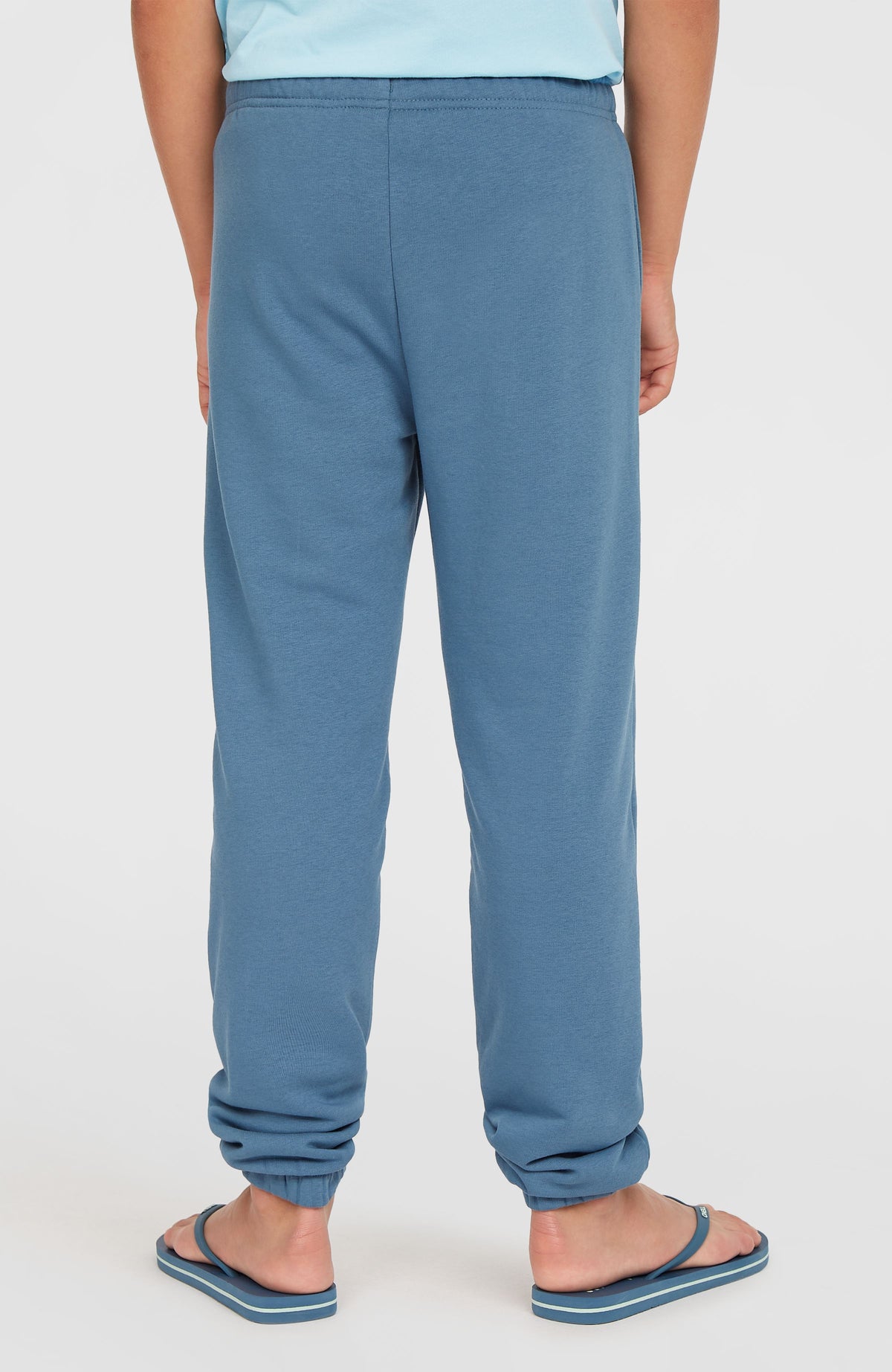 Blaue Logo Jogginghose für Jungen, Rückansicht mit elastischem Bund und Bündchen, getragen am Model