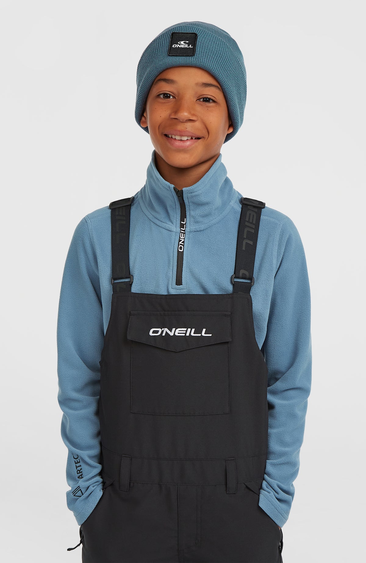 FWC'Cruz Bib Skihose für Kinder, schwarz, Nahaufnahme von Brustlatz mit Logo-Aufdruck und Trägern am Model