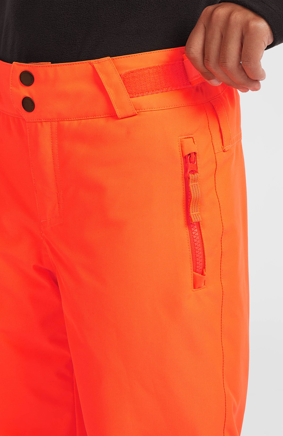 Nahaufnahme der roten FWC'Cruz Skihose am Model mit seitlicher Reißverschlusstasche
