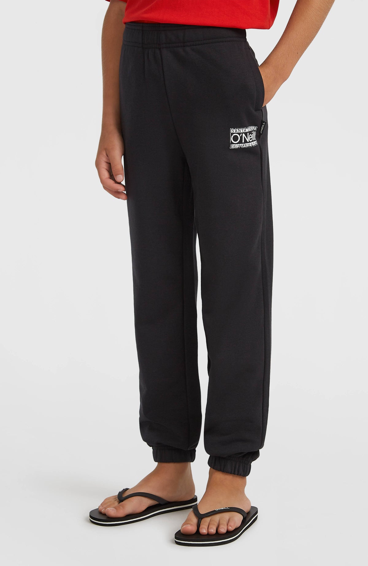Cali Jogginghose für Jungen, schwarz mit Logo-Print in Weiß, Halbprofil getragen am Model