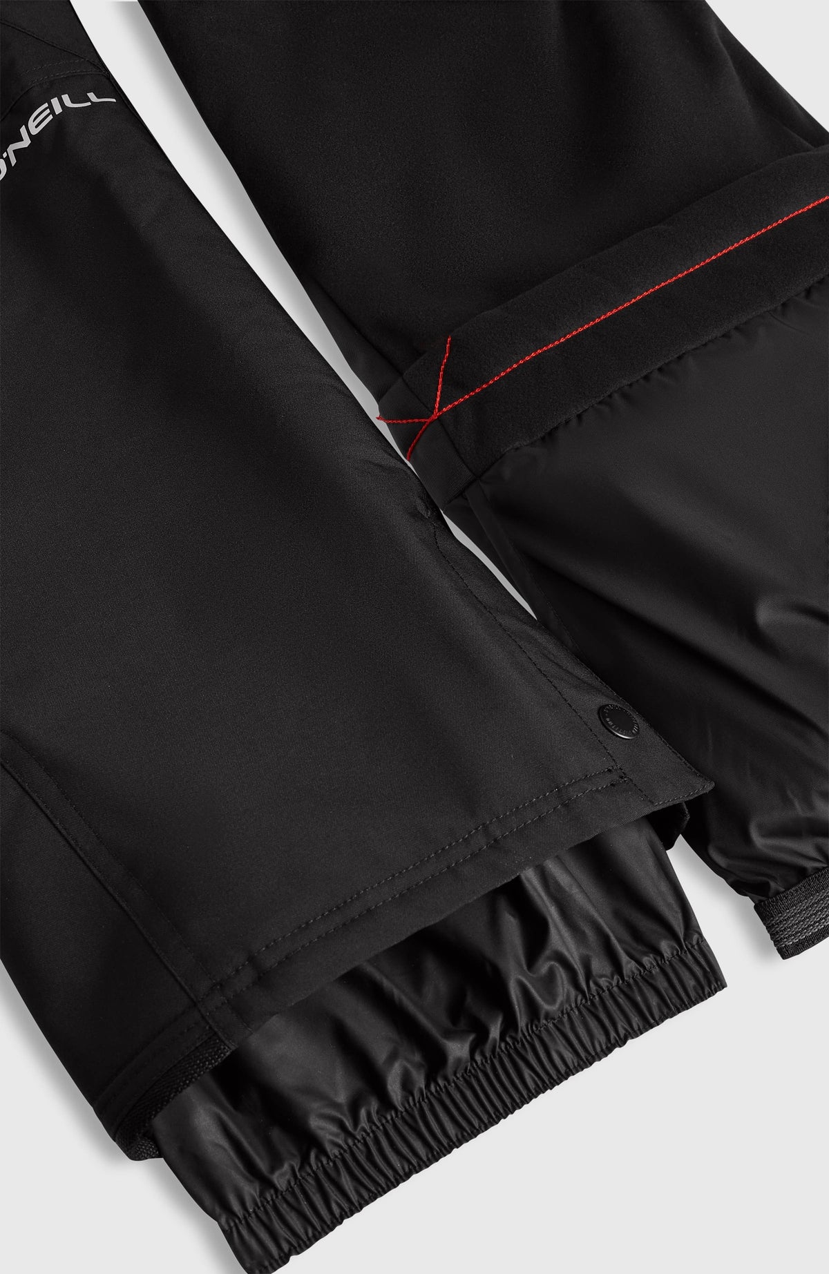 FWC'Cruz Bib Skihose für Jungen, schwarz, Nahaufnahme der Hosenbeine mit integriertem elastischem Schneefang