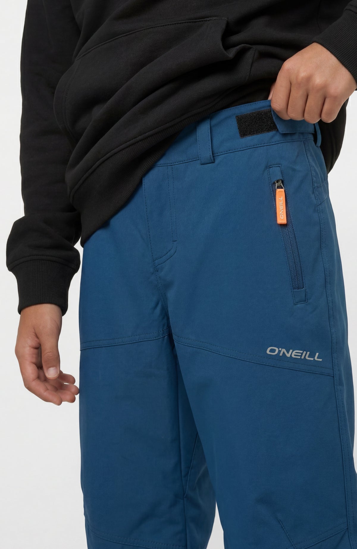 FWC'Cruz Skihose für Jungen, blau, Nahaufnahme der seitlichen Reißverschlusstasche mit orangefarbenem Anhänger