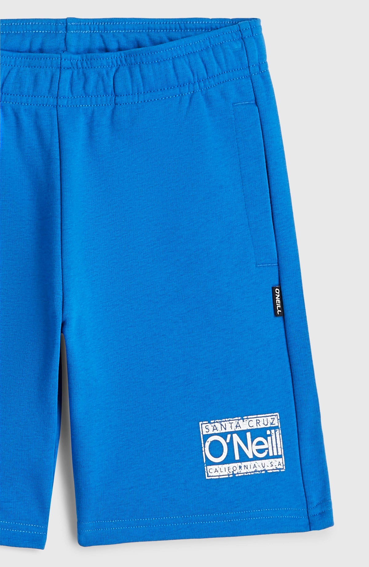 Nahaufnahme der blauen Cali Sweatshorts für Jungen mit Logo-Print in Weiß und Seitentasche, flach liegend