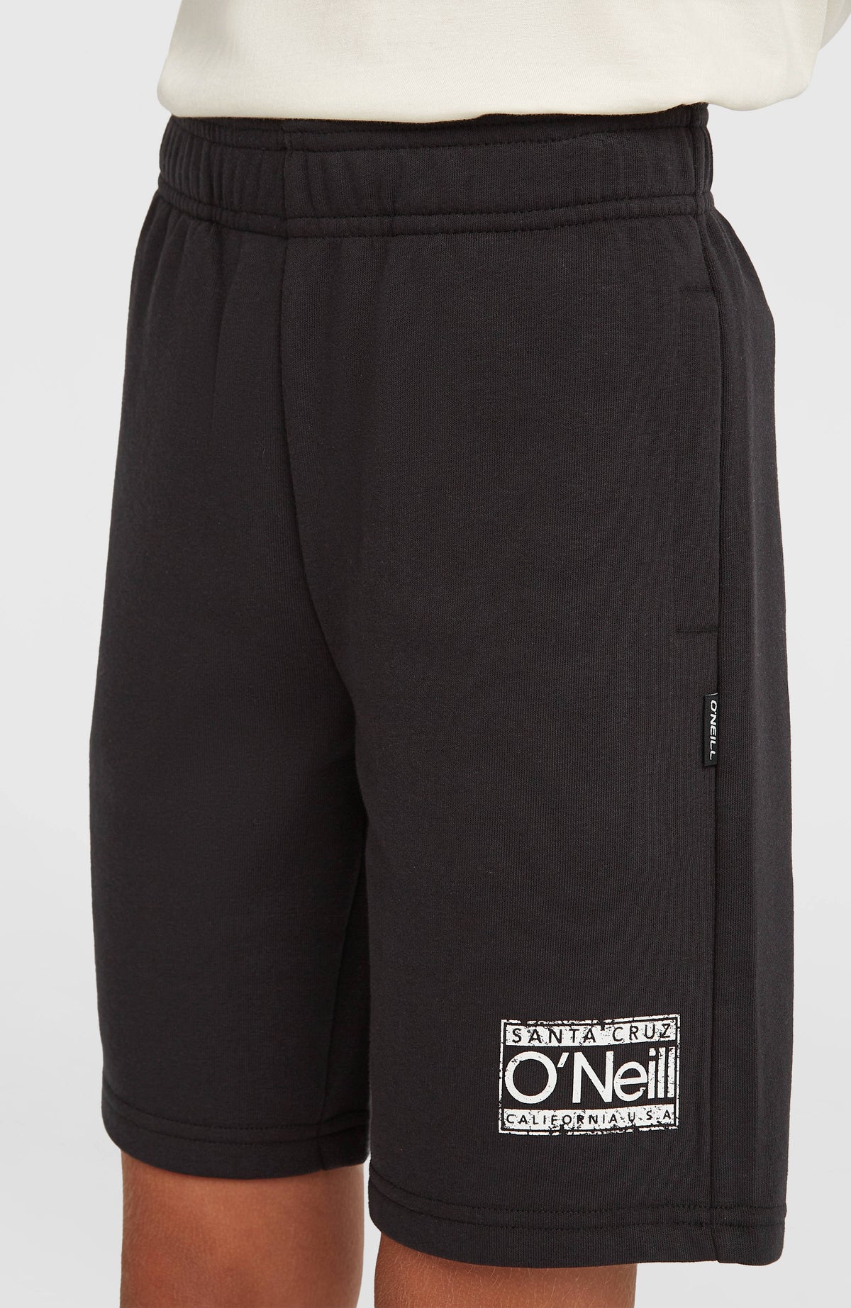 O'Neill Cali Sweatshorts für Jungen, schwarz mit Logo-Print in Weiß, Nahaufnahme am Model