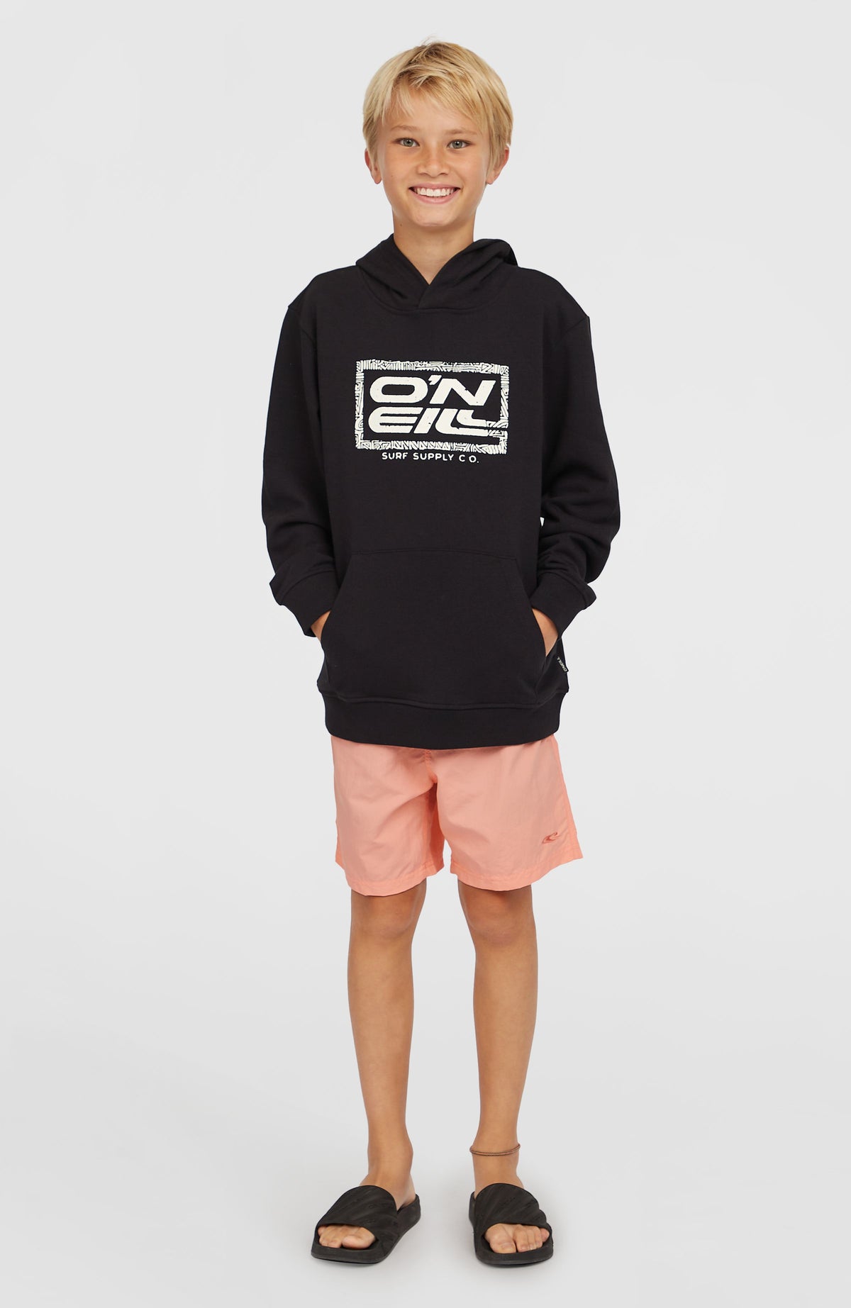Logo Hoodie für Jungen, schwarz mit Logo-Print in Weiß, Ganzkörperansicht getragen am Model mit Kängurutasche