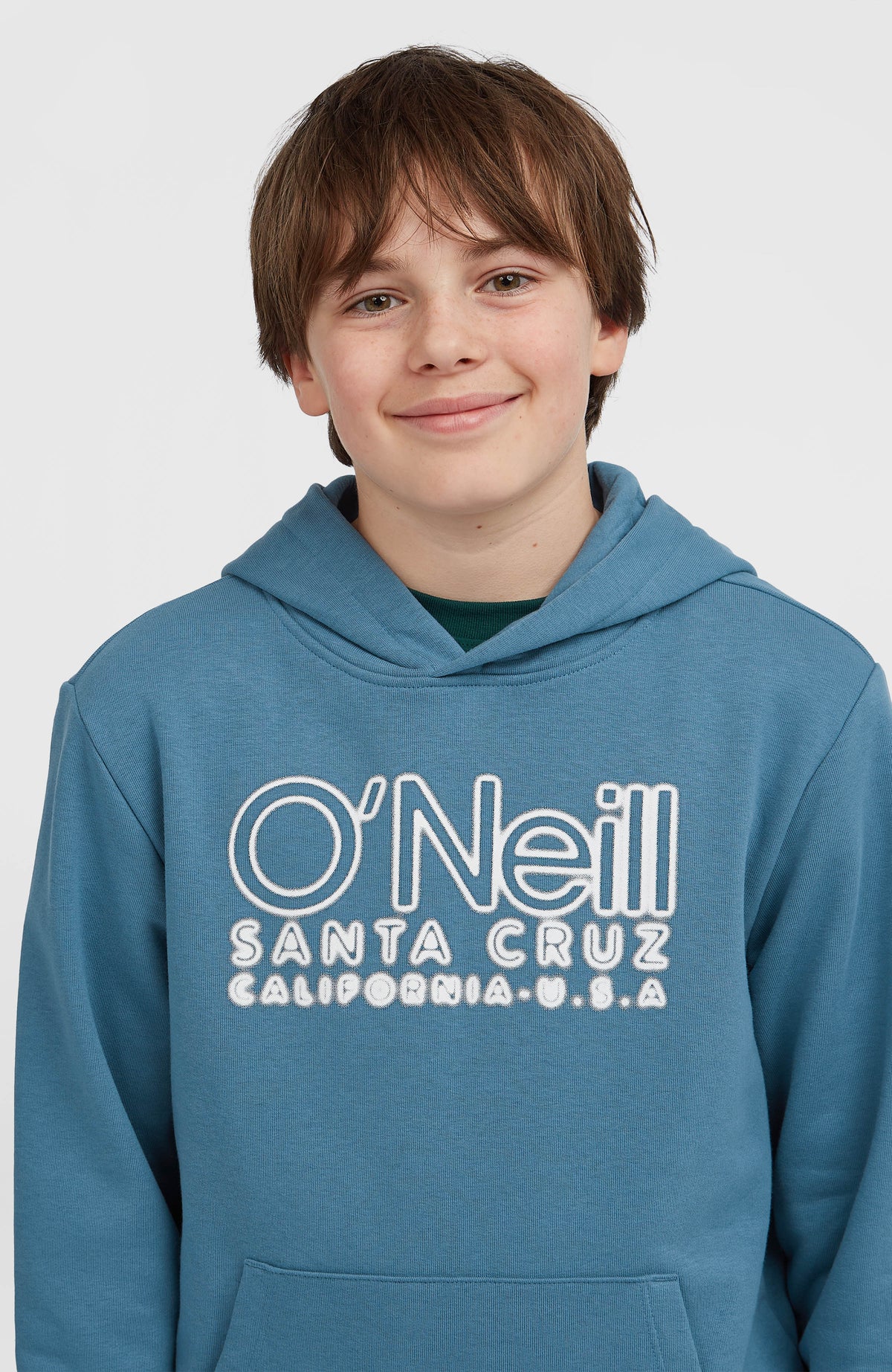 Essentials Hoodie für Jungen, blau mit Logo-Stickerei in Weiß, Nahaufnahme des oberen Brustbereichs am Model