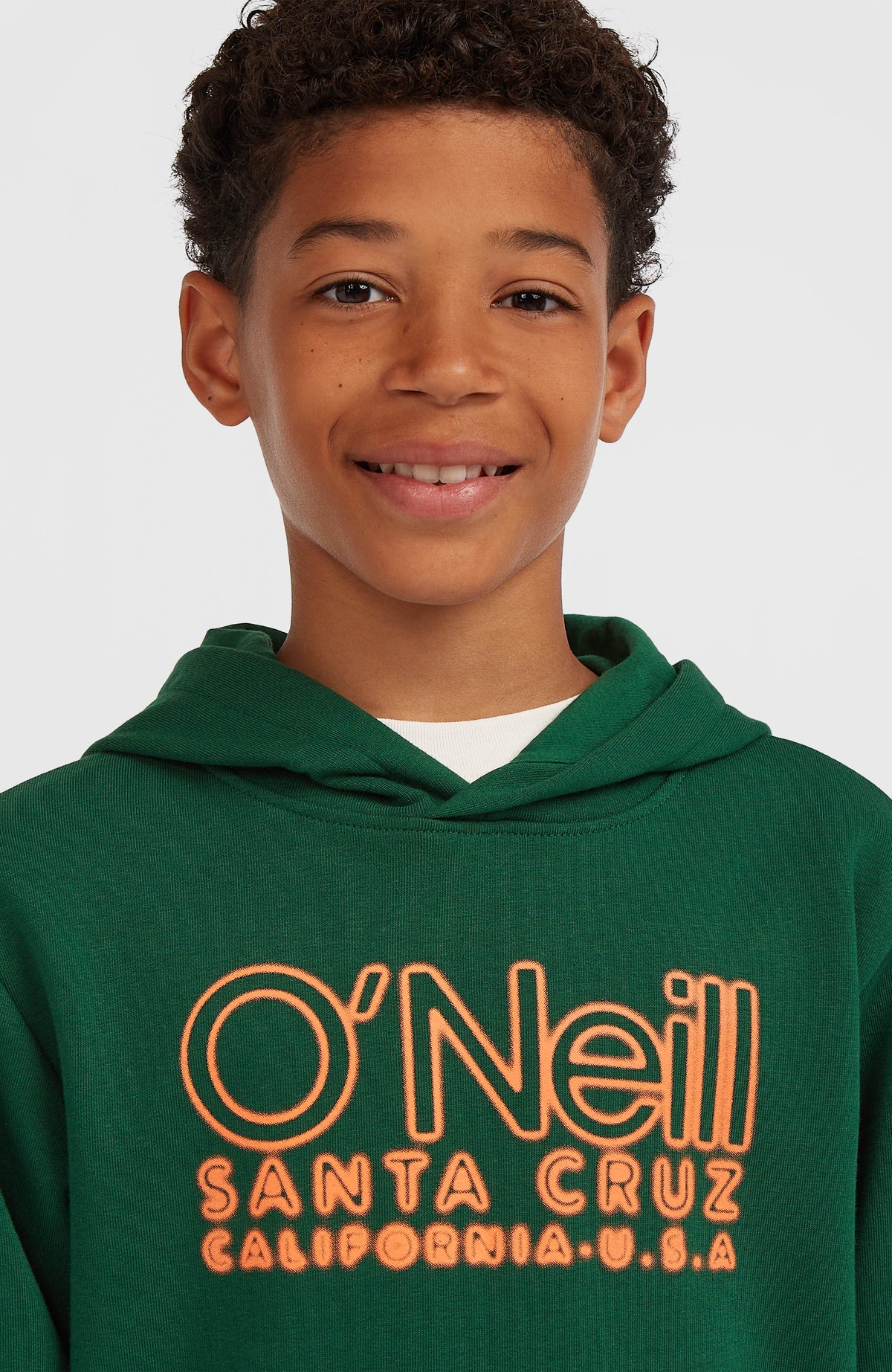 Essentials Hoodie für Jungen, grün mit Logo-Print in Orange, Nahaufnahme des Brustbereichs am Model