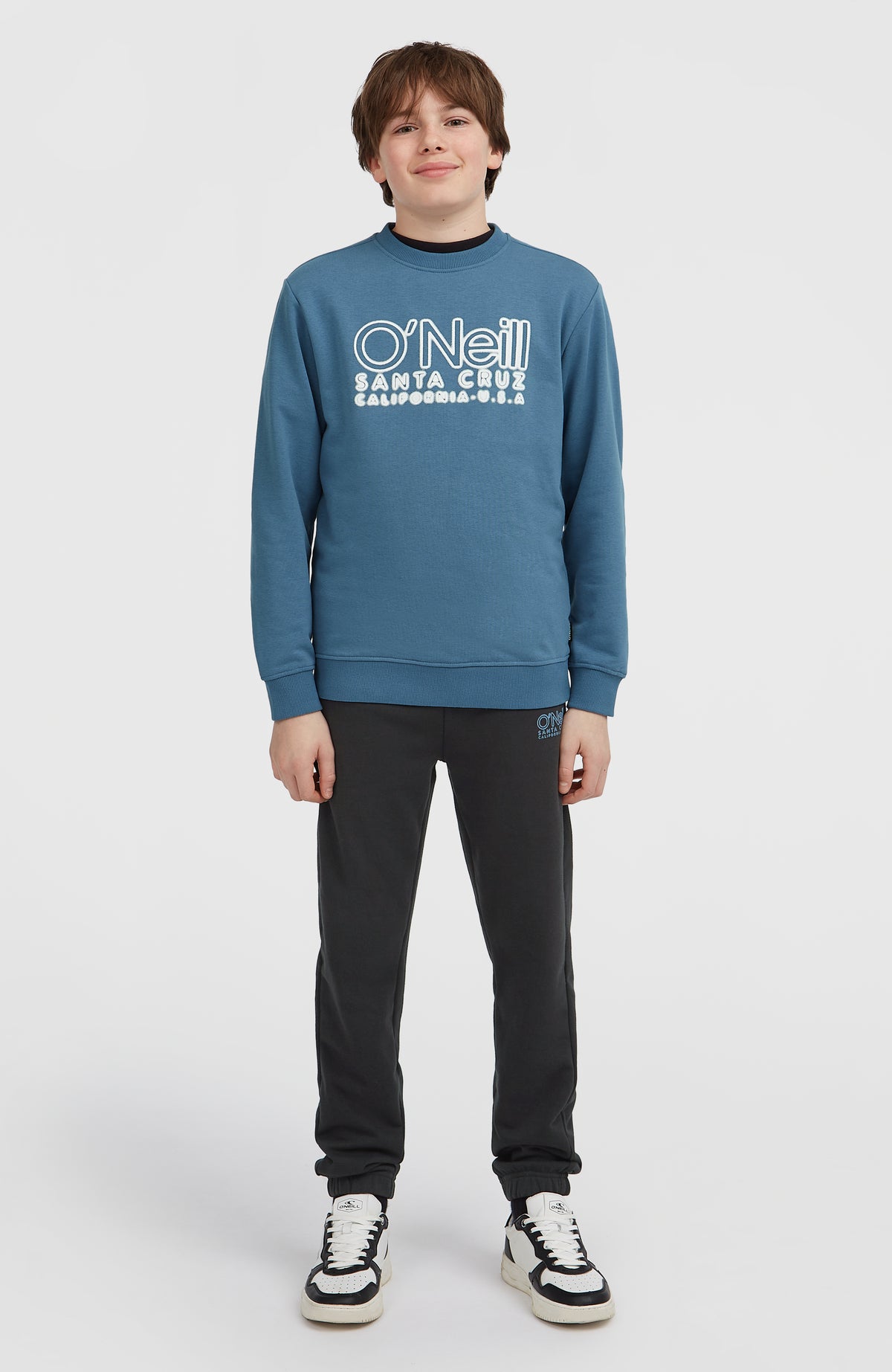 Essentials Crew Sweatshirt für Jungen, blau mit Logo-Stickerei in Weiß, Ganzkörperansicht, am Model