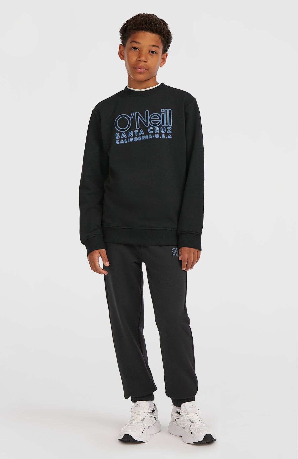 Essentials Crew Sweatshirt für Jungen, schwarz mit Logo-Print in Hellblau, Ganzkörperansicht getragen am Model