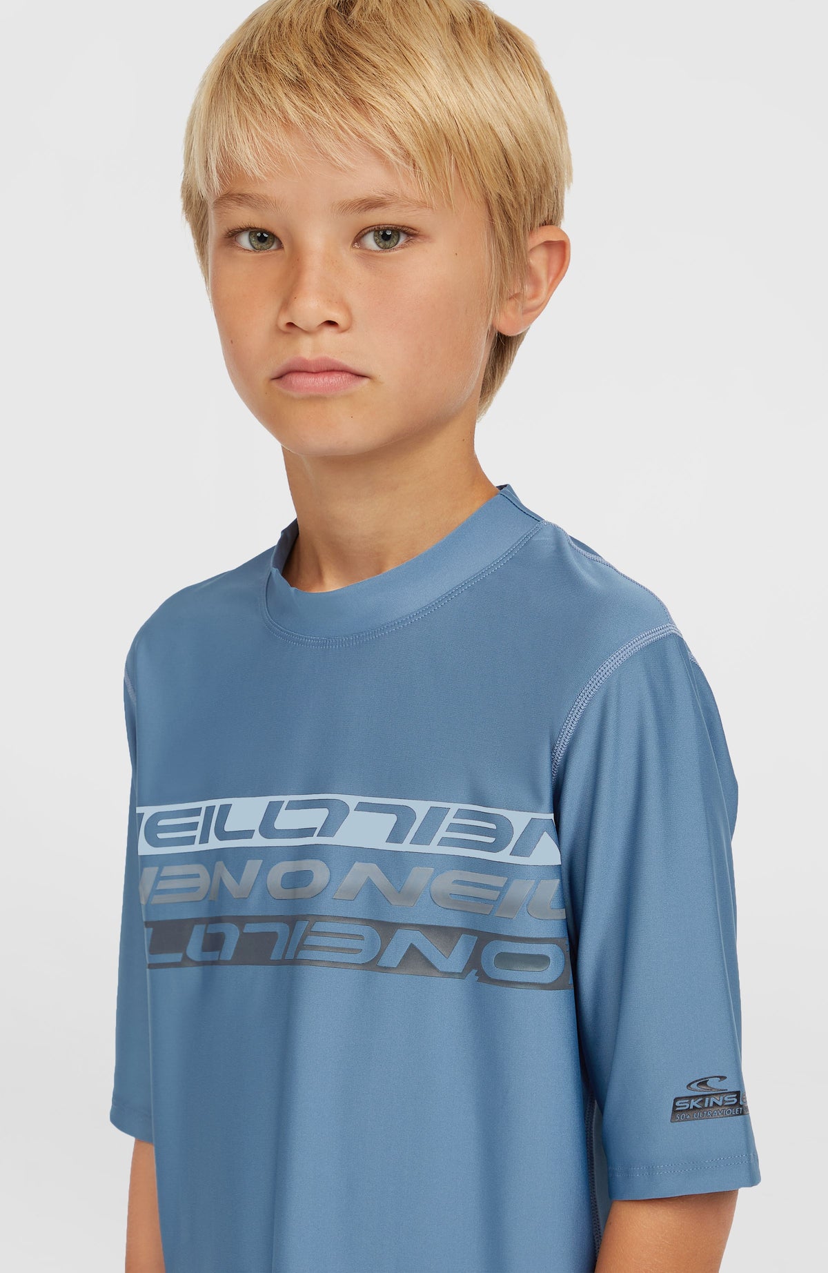 Nahaufnahme des blauen Shortsleeve-Schwimmshirt für Jungen mit Logo-Print in Hellblau und Dunkelgrau, getragen am Model