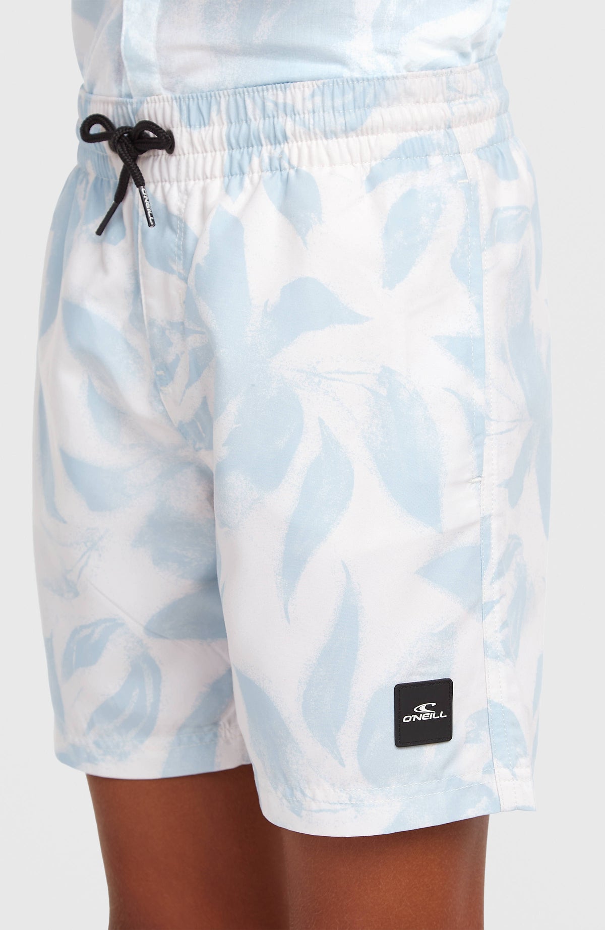 O'Neill Print Badehose für Jungen, weiß mit Blumenmuster in Hellblau, Vorderansicht am Model mit Logo-Patch