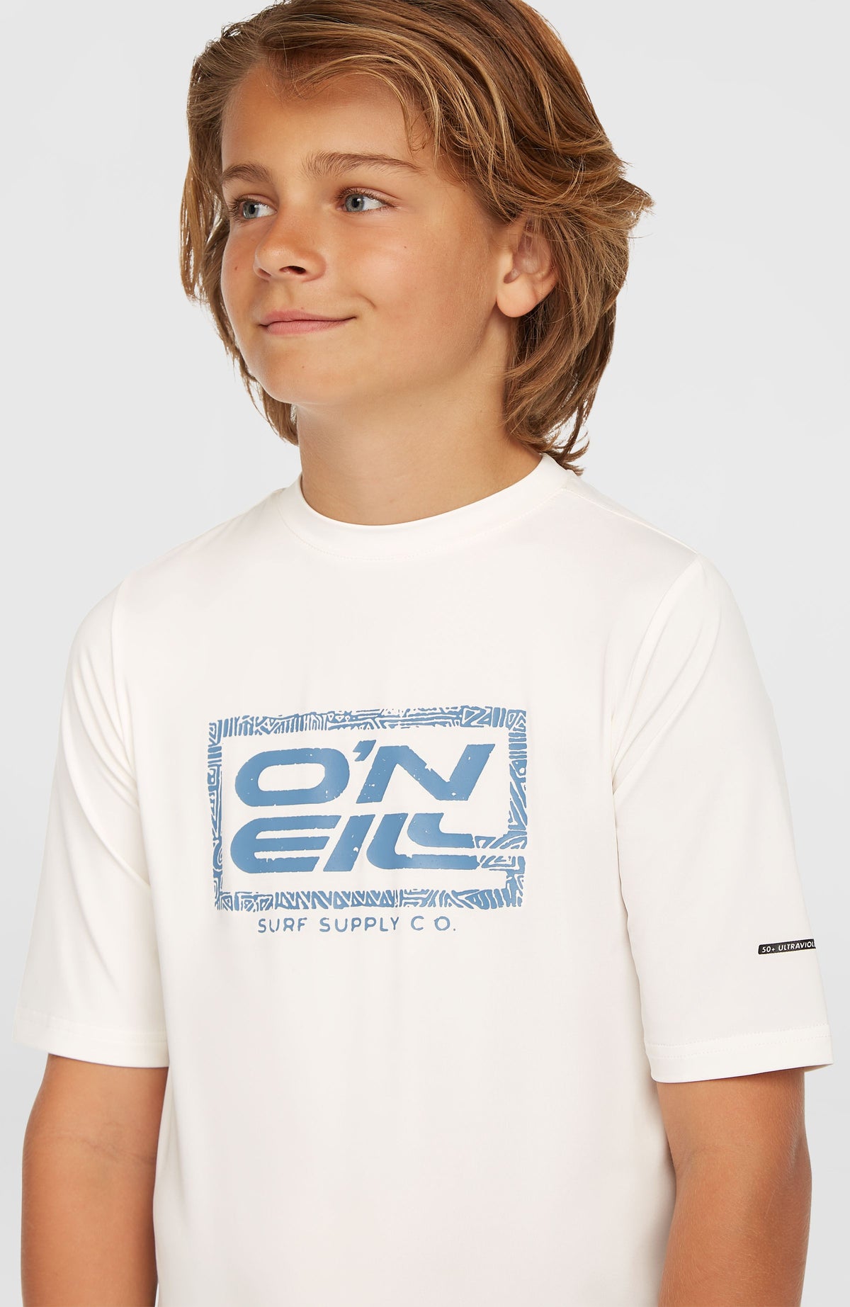 Nahaufnahme des blauen Logo-Prints auf der Brust des weißen Hybrid T-Shirts für Jungen