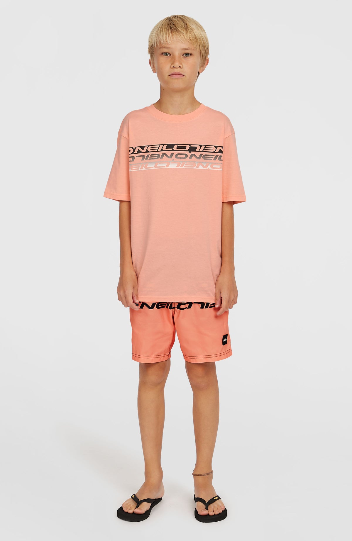 Stripe T-Shirt für Jungen, pink mit Logo-Print in Schwarz und Weiß, Ganzkörperansicht von vorne am Model