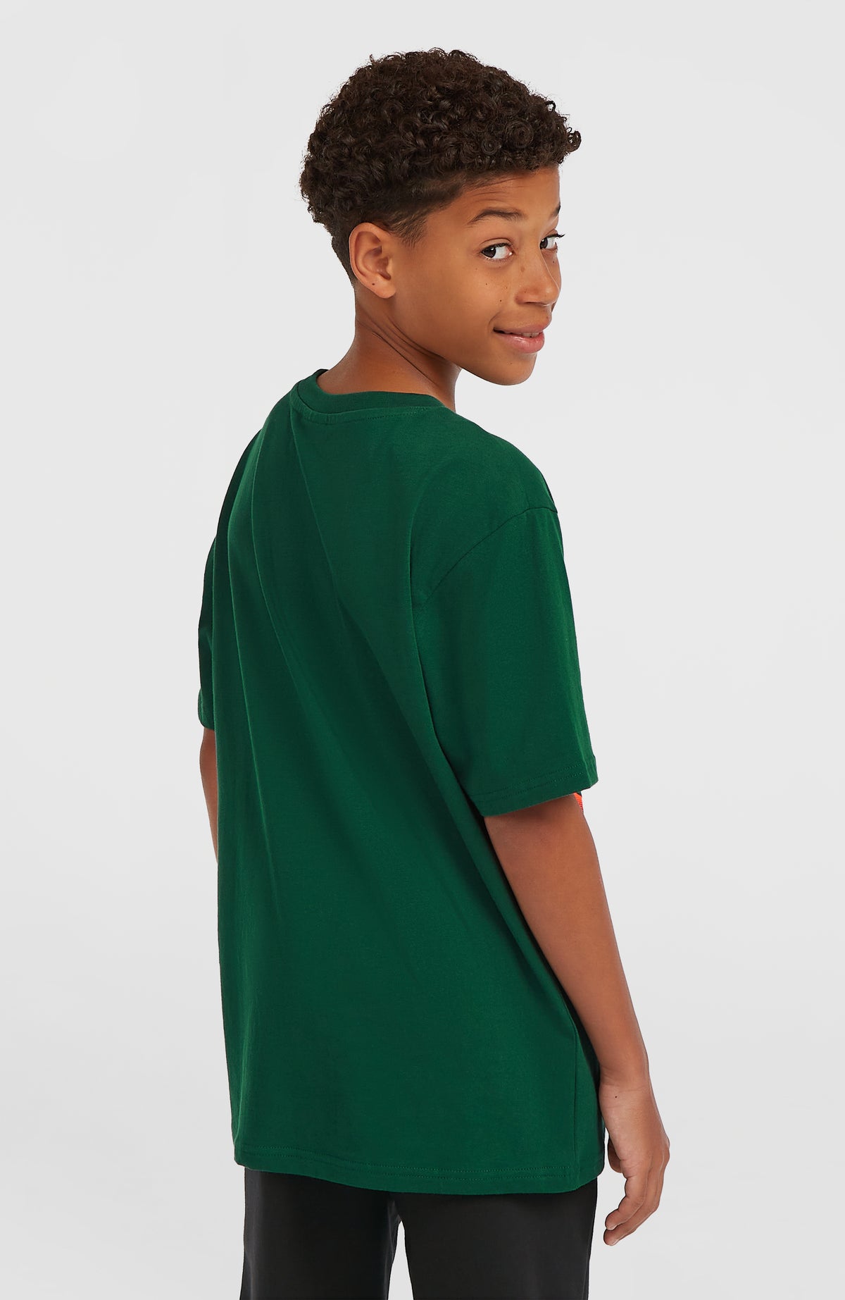 Wave T-Shirt für Jungen, grün, getragen am Model, unifarbene Rückansicht von schräg hinten