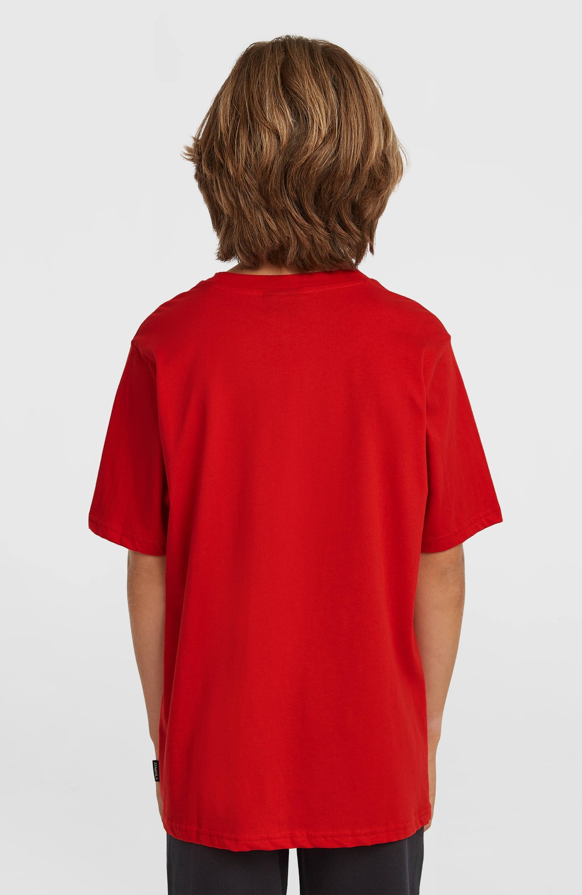 Cali T-Shirt für Jungen, rot, Rückansicht am Model mit seitlichem Label am Saum